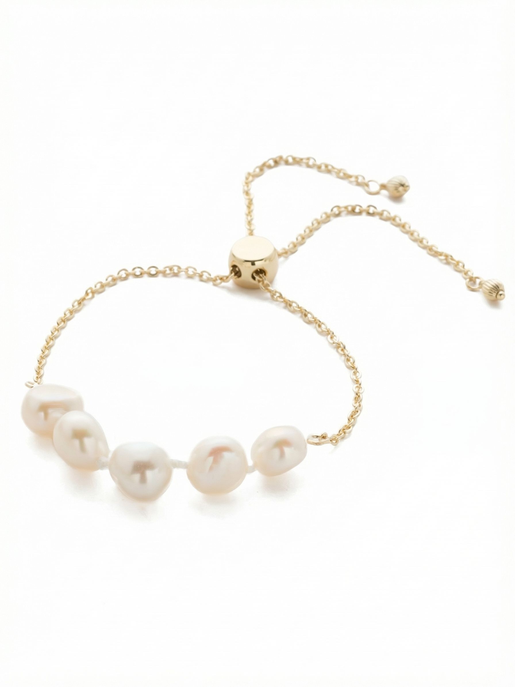 Celeste Slider Bracelet - 4BEF2BGMDP - <p>Five white pearls anchor this delicate design, bringing organic texture and quiet luminescence to your daily stack. The fine cable chain balances the visual weight of the pearls, while the sliding closure allows you to adjust the fit exactly to your liking. Wear it solo for a subtle gleam, or let it soften harder metallic pieces in a layered arrangement. The trailing chain ends catch the light with every movement of your hand.</p><ul>
<li>Five organically shaped pearls grouped to create a prominent focal point</li>
<li>Chain ornaments add kinetic movement as you wear it</li>
<li>Adjustable slider closure</li>
<li>Protective e-coat finish for lasting wear</li>
<li>Includes signature organza pouch for gifting and travel</li>
</ul>