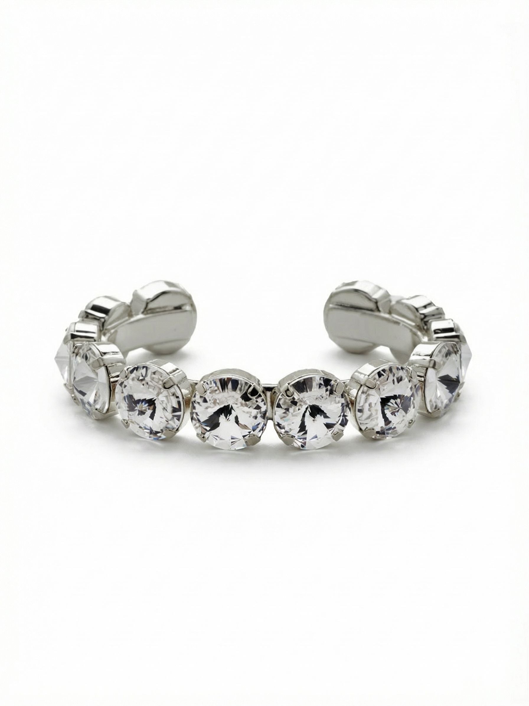 Nadine Cuff Bracelet - 4BEZ17PDCRY - <p>A solid band of substantial round crystals creates an unbroken line of light right at your cuff. The open design slides easily onto the wrist, offering immediate presence and a secure fit without the need to navigate a clasp. These fourteen millimeter stones carry significant weight and scale, making this bracelet strong enough to anchor your look entirely on its own. The clear crystals catch and reflect your environment, blending naturally into your daily routine while adding a polished weight to your movements.</p><ul>
<li>Continuous band of oversized fourteen millimeter round crystals</li>
<li>Rigid structure maintains an unbroken circle of light</li>
<li>Adjustable open cuff slides on easily</li>
<li>Protective e-coat finish for lasting wear</li>
<li>Includes signature organza pouch for gifting and travel</li>
</ul>
