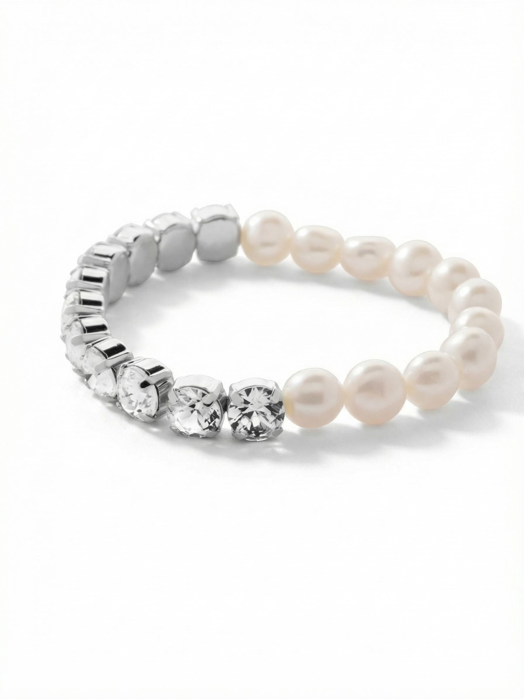 Pearl and Crystal Stretch Bracelet - 4BFJ41PDMDP - <p>Half organic pearl and half faceted crystal, this stretch bracelet is a study in quiet contrast. The smooth baroque pearls bring a warm, irregular luster that plays against the sharp geometry of the clear round-cut crystals. The flexible design rolls effortlessly over your hand, becoming an easy addition to a hurried morning routine. Its dual nature means the look shifts slightly as it moves, making it a natural companion next to a watch or stacked with rigid metal cuffs.</p><ul>
<li>Split design contrasting irregular baroque pearls with a continuous line of clear crystals</li>
<li>The dual composition allows the visual rhythm to shift as the bracelet naturally turns</li>
<li>Stretch easy slip-on design</li>
<li>Protective e-coat finish for lasting wear</li>
<li>Includes signature organza pouch for gifting and travel</li>
</ul>
