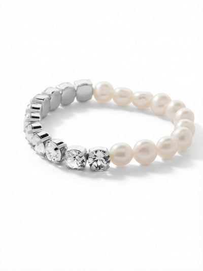 Pearl and Crystal Stretch Bracelet - 4BFJ41PDMDP - <p>Half organic pearl and half faceted crystal, this stretch bracelet is a study in quiet contrast. The smooth baroque pearls bring a warm, irregular luster that plays against the sharp geometry of the clear round-cut crystals. The flexible design rolls effortlessly over your hand, becoming an easy addition to a hurried morning routine. Its dual nature means the look shifts slightly as it moves, making it a natural companion next to a watch or stacked with rigid metal cuffs.</p><ul>
<li>Split design contrasting irregular baroque pearls with a continuous line of clear crystals</li>
<li>The dual composition allows the visual rhythm to shift as the bracelet naturally turns</li>
<li>Stretch easy slip-on design</li>
<li>Protective e-coat finish for lasting wear</li>
<li>Includes signature organza pouch for gifting and travel</li>
</ul>