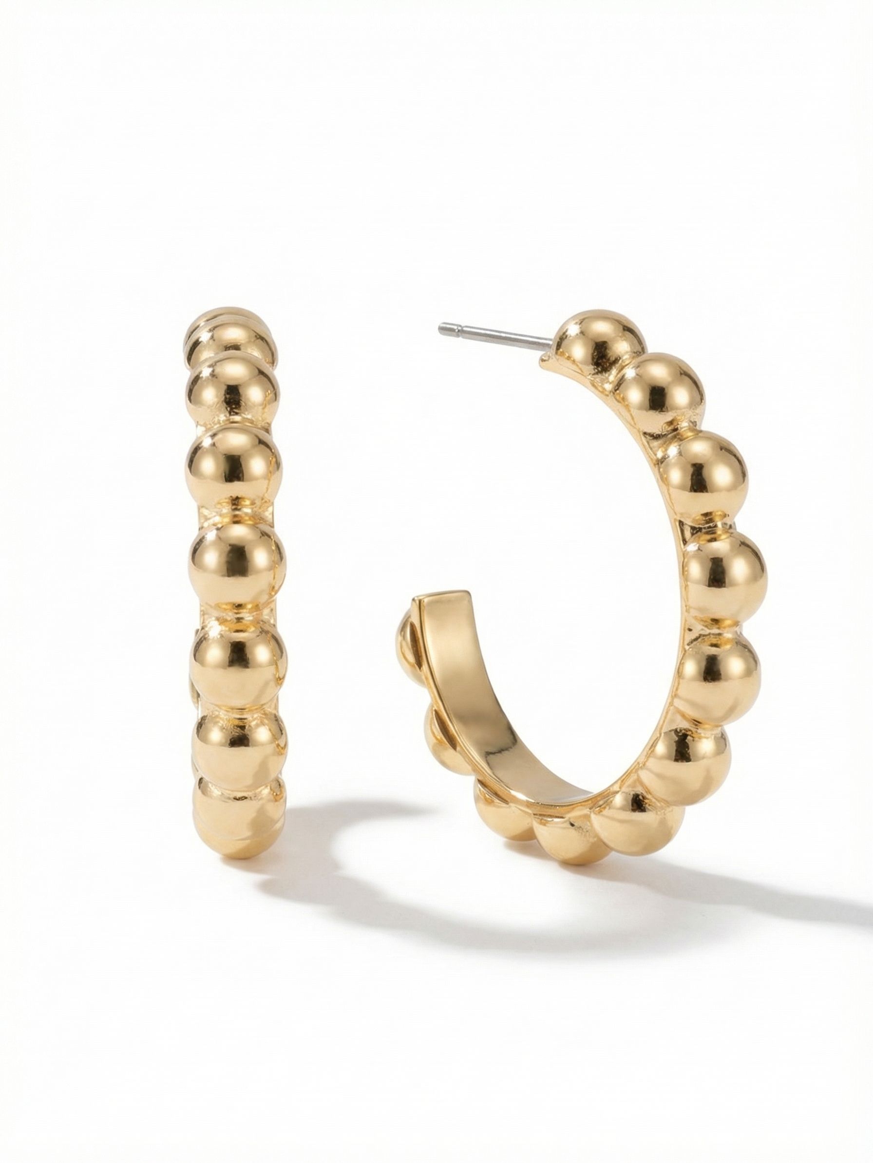 Bauble Hoop Earrings - 4EFL12BGMTL - <p>A sculptural update to the everyday hoop, these earrings arrange polished metallic spheres into a clean open curve. The bright gold finish catches light continuously as you move, giving them a bold presence that reads clearly at conversation distance. Built with a flat inner profile, they deliver visual volume without a heavy feel. Secured by a post and an oversized comfort clutch, they stay flush and perfectly balanced from morning to night.</p><ul>
<li>Continuous row of polished spheres creates a highly reflective surface</li>
<li>Flat inner structure provides bold visual volume with a lightweight feel</li>
<li>Post with oversized comfort-clutch back</li>
<li>Protective e-coat finish for lasting wear</li>
<li>Includes signature organza pouch for gifting and travel</li>
</ul>