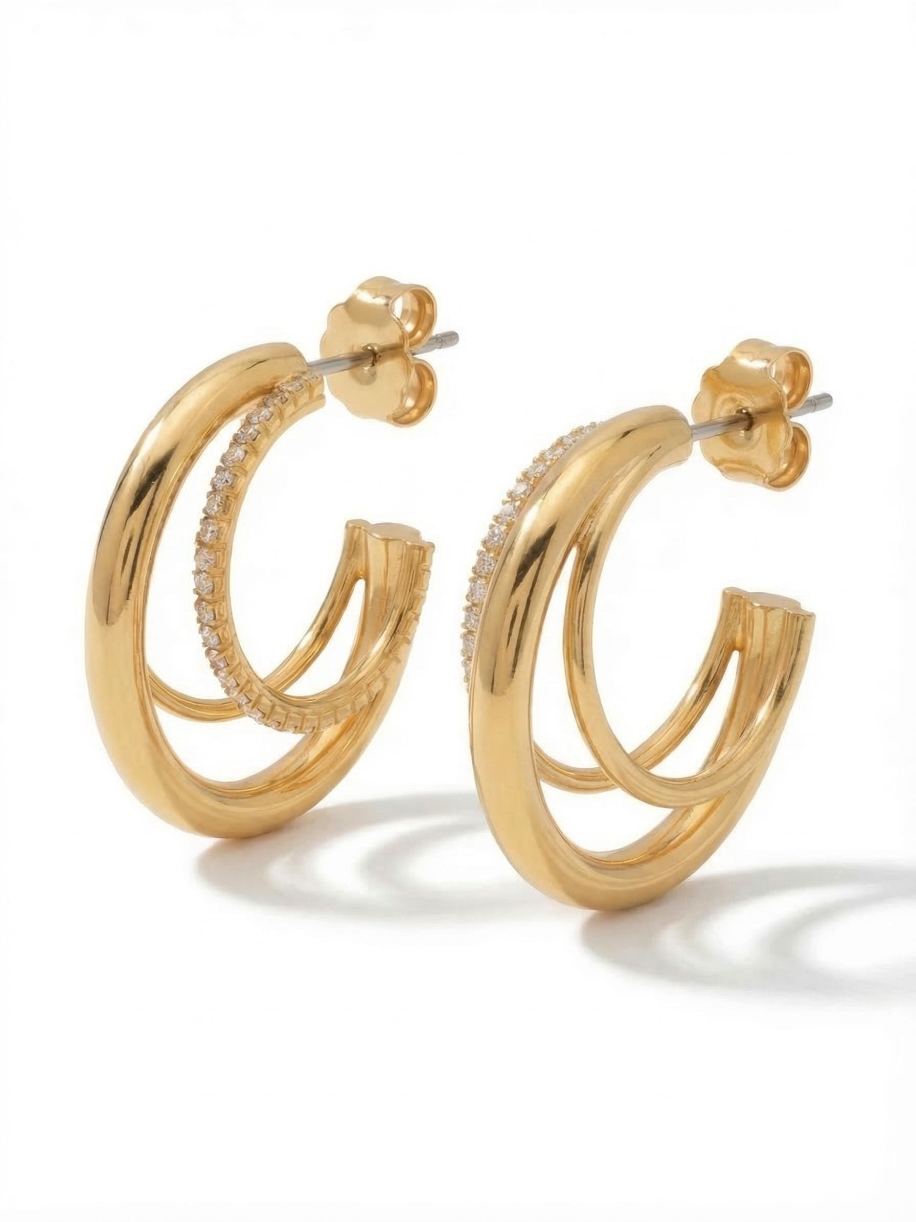 Trio Crystal Hoop Earrings - 4EFP16BGCRY - <p>These layered hoops create the illusion of a stacked ear in a single piece. A thick band of polished gold anchors the design, framed by a delicate line of crystals and a slender outer hoop. The clear stones catch the light as you move, adding subtle texture to your daily uniform. A pressure-fit comfort back keeps the rounded profile sitting flush and secure against the lobe from morning until evening.</p><ul>
<li>Triple-layered design combining smooth polished bands and a delicate rhinestone chain</li>
<li>Hoop post with a pressure-fit comfort back for a secure hold throughout the day</li>
<li>Includes signature organza pouch for gifting and travel</li>
</ul>