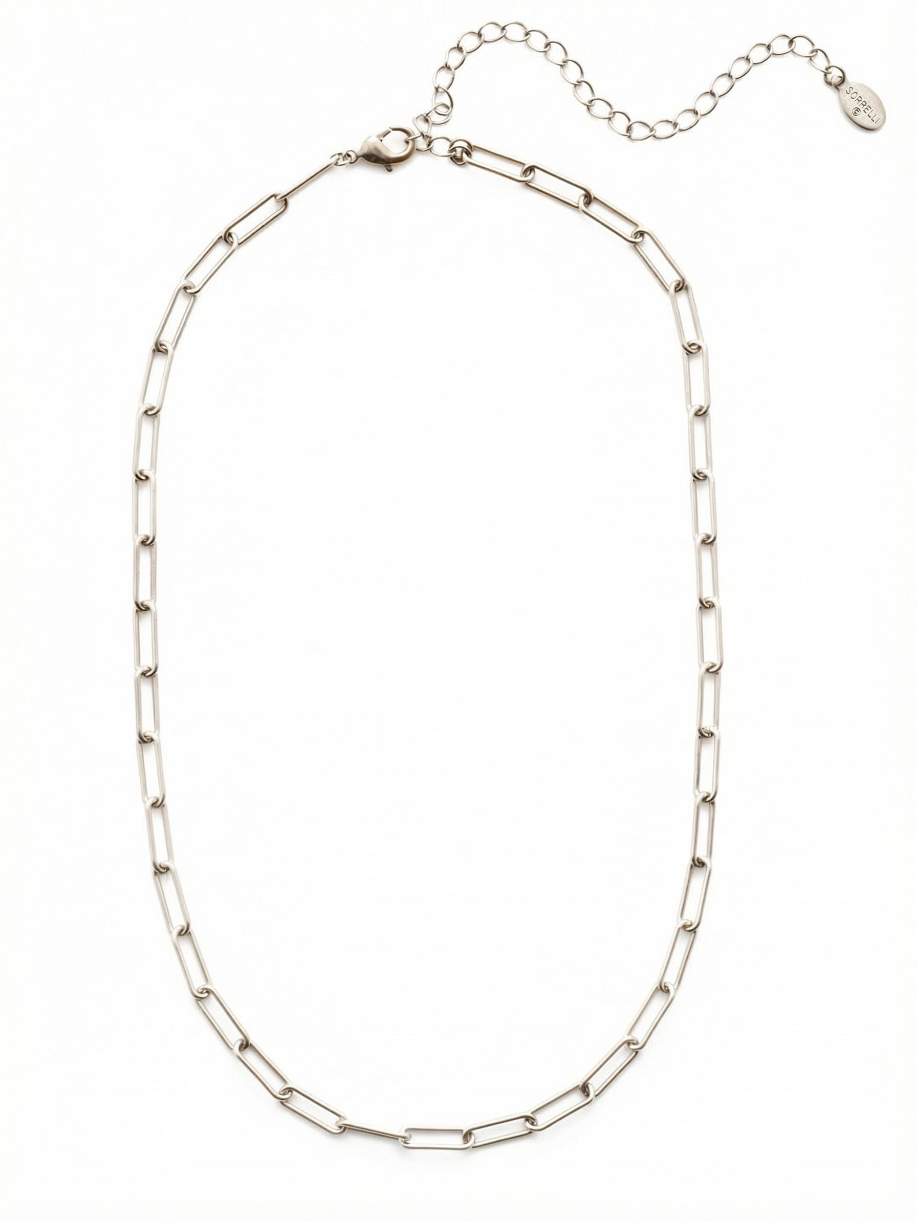 Jacinda Tennis Necklace - 4NES13PDCRY - <p>The elongated, open links of this paperclip chain introduce a clean, structural rhythm to your neckline. Polished metal reflects light evenly as you move, while the airy construction provides an architectural presence without adding heavy weight. The open design allows the necklace to drape naturally along the collarbone. Thanks to the integrated extension chain, you can easily adjust the drop, making this an intuitive foundation for daily layering or a quiet anchor worn solo.</p><ul>
<li>Elongated open links create a clean structural geometry</li>
<li>Airy paperclip construction ensures a fluid natural drape</li>
<li>Lobster claw clasp</li>
<li>4-inch adjustable extension chain</li>
<li>Protective e-coat finish for lasting wear</li>
<li>Includes signature organza pouch for gifting and travel</li>
</ul>