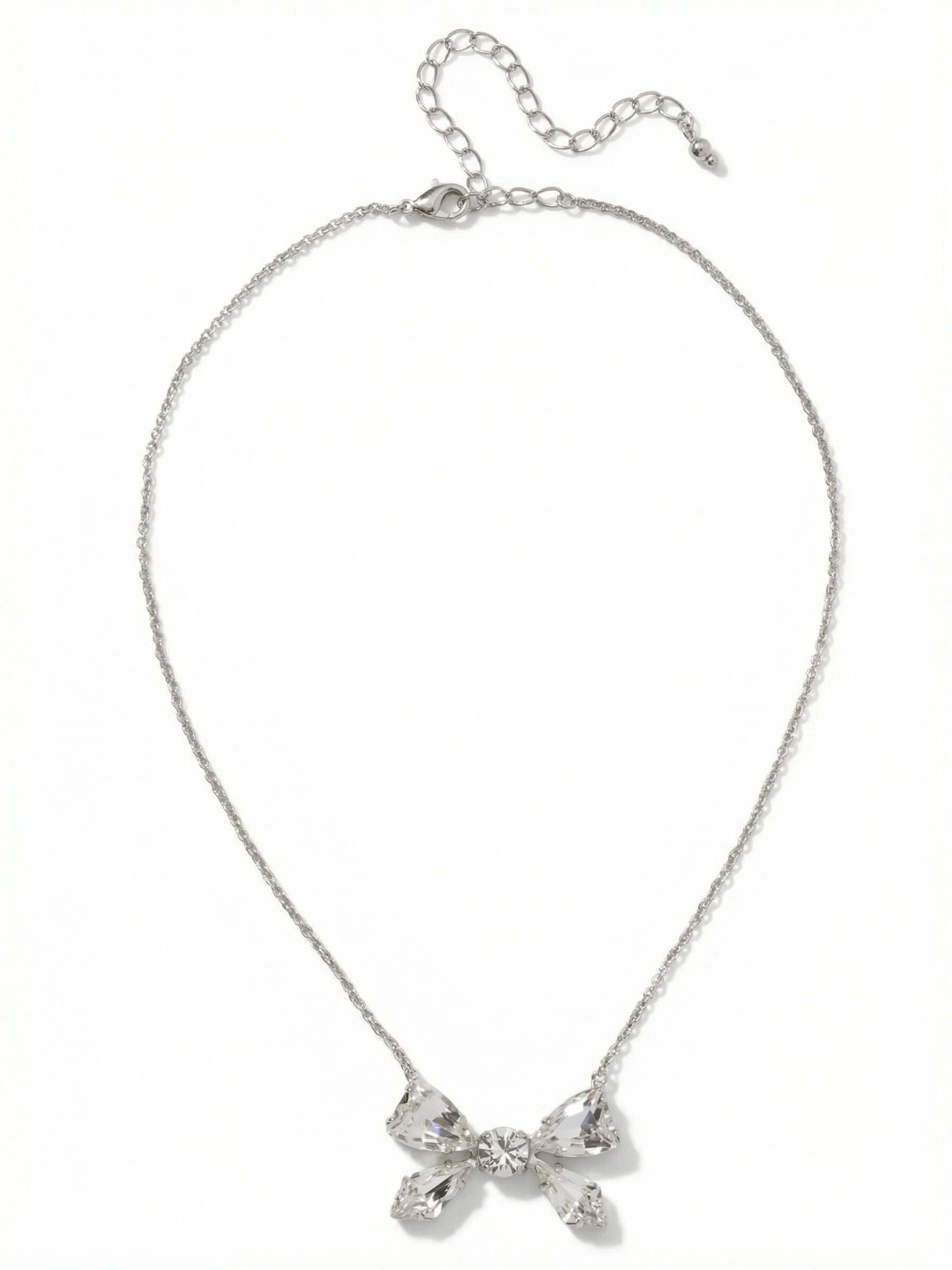 Colette Pendant Necklace - 4NFZ5PDCRY - <p>A playful yet precise arrangement of faceted clear crystals forms a structured bow motif that rests neatly at the collarbone. The cool-toned palladium setting catches the light with subtle intensity, contrasting with the fine cable chain that drapes effortlessly across the skin. With an extension chain to fine-tune the placement, this pendant balances a delicate shape with undeniable presence. It brings a composed, quiet brilliance to an open neckline.</p><ul>
<li>Structured bow motif constructed from five distinct faceted crystals</li>
<li>Fine cable chain allows the crystal arrangement to remain the focal point</li>
<li>Lobster claw clasp</li>
<li>4-inch adjustable extension chain</li>
<li>Protective e-coat finish for lasting wear</li>
<li>Includes signature organza pouch for gifting and travel</li>
</ul>