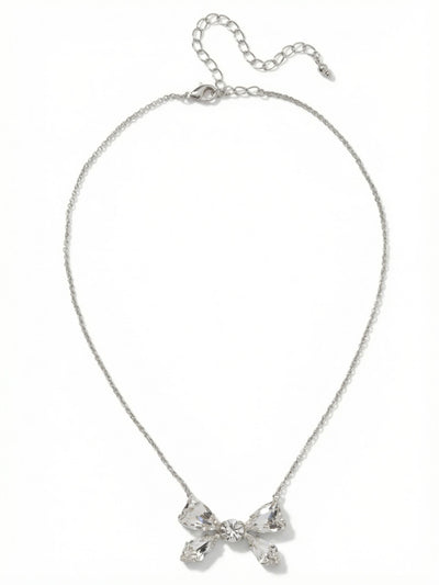 Colette Pendant Necklace - 4NFZ5PDCRY - <p>A playful yet precise arrangement of faceted clear crystals forms a structured bow motif that rests neatly at the collarbone. The cool-toned palladium setting catches the light with subtle intensity, contrasting with the fine cable chain that drapes effortlessly across the skin. With an extension chain to fine-tune the placement, this pendant balances a delicate shape with undeniable presence. It brings a composed, quiet brilliance to an open neckline.</p><ul>
<li>Structured bow motif constructed from five distinct faceted crystals</li>
<li>Fine cable chain allows the crystal arrangement to remain the focal point</li>
<li>Lobster claw clasp</li>
<li>4-inch adjustable extension chain</li>
<li>Protective e-coat finish for lasting wear</li>
<li>Includes signature organza pouch for gifting and travel</li>
</ul>