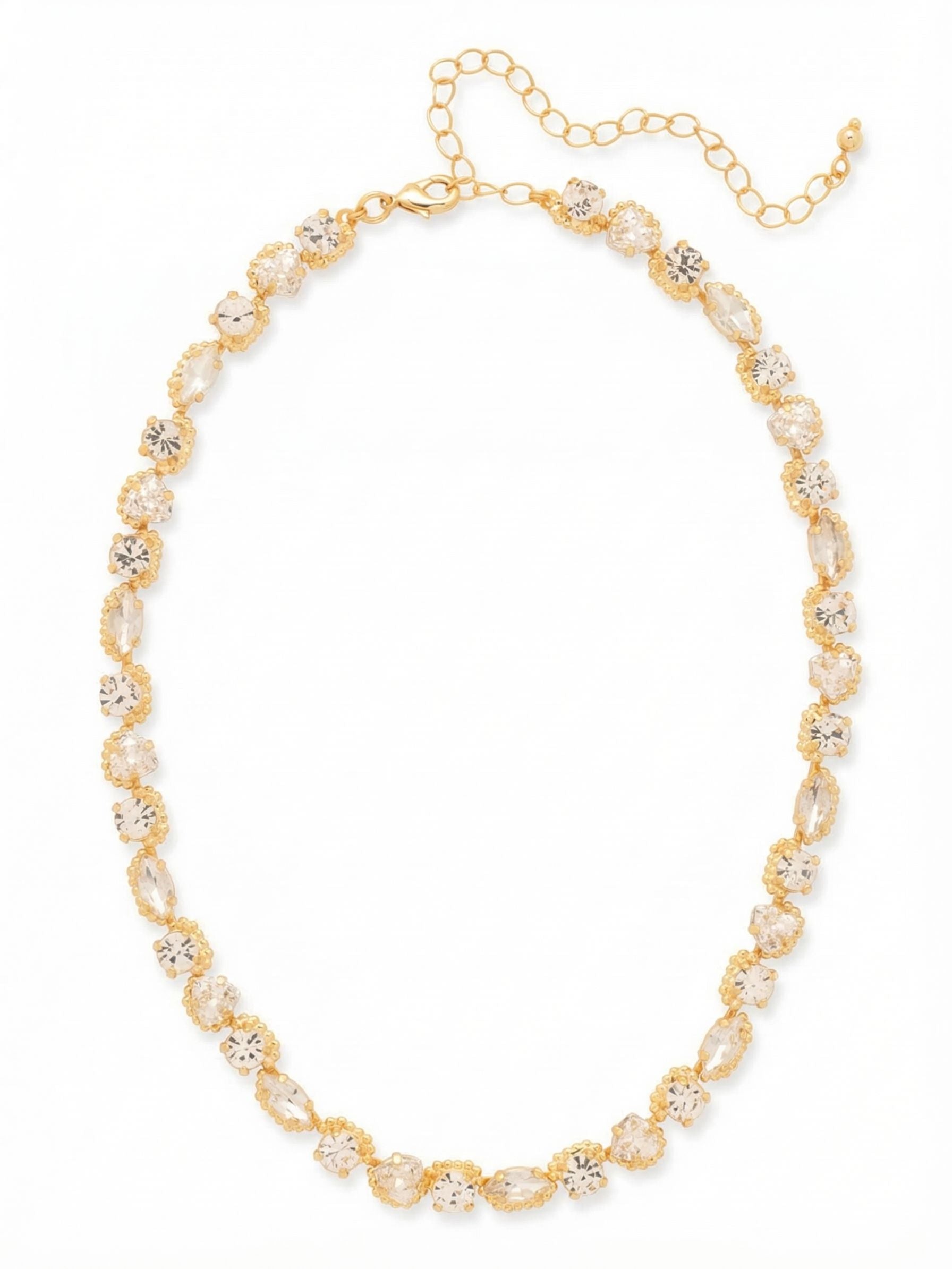 Rene Tennis Necklace - 4NGI3BGCRY - <p>The Rene Tennis Necklace reimagines the traditional uniform line through a continuous rhythm of varied shapes. Round, marquise, and trillion crystals alternate along the collar, catching light from different angles as the piece moves with you. The beaded texture of the gold-tone setting adds subtle dimension to the unbroken sequence of clear stones. Built to drape naturally along the collarbone, this necklace includes an extension chain so you can easily adjust the drop to complement an open neckline or layer beneath a longer pendant.</p><ul>
<li>Rhythmic sequence of alternating round, marquise, and trillion cut crystals</li>
<li>Beaded texture around each setting adds dimension to the continuous line</li>
<li>Lobster claw clasp</li>
<li>4-inch adjustable extension chain</li>
<li>Protective e-coat finish for lasting wear</li>
<li>Includes signature organza pouch for gifting and travel</li>
</ul>
