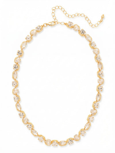 Rene Tennis Necklace - 4NGI3BGCRY - <p>The Rene Tennis Necklace reimagines the traditional uniform line through a continuous rhythm of varied shapes. Round, marquise, and trillion crystals alternate along the collar, catching light from different angles as the piece moves with you. The beaded texture of the gold-tone setting adds subtle dimension to the unbroken sequence of clear stones. Built to drape naturally along the collarbone, this necklace includes an extension chain so you can easily adjust the drop to complement an open neckline or layer beneath a longer pendant.</p><ul>
<li>Rhythmic sequence of alternating round, marquise, and trillion cut crystals</li>
<li>Beaded texture around each setting adds dimension to the continuous line</li>
<li>Lobster claw clasp</li>
<li>4-inch adjustable extension chain</li>
<li>Protective e-coat finish for lasting wear</li>
<li>Includes signature organza pouch for gifting and travel</li>
</ul>