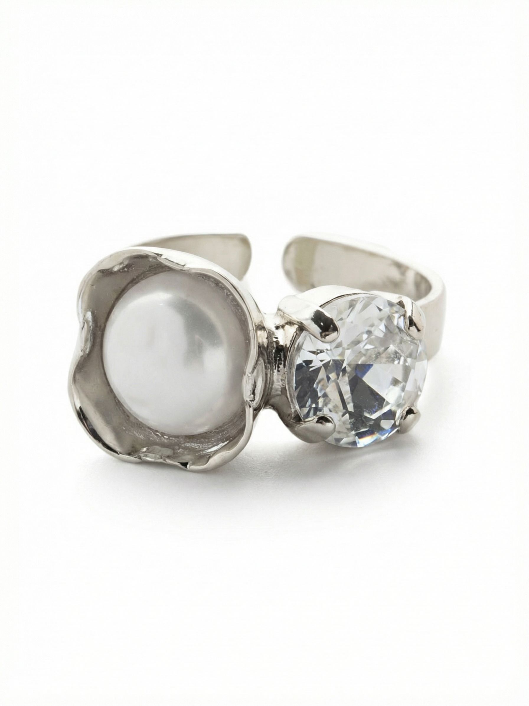 Kaylee Cocktail Ring - 4REV8PDMDP - <p>This open-front design plays with texture and contrast on the hand. On one side, a bright round crystal catches the light with sharp facets. On the other, a smooth white pearl rests inside a sculptured, wavy metal cup. The asymmetrical pairing gives the ring a modern, architectural feel that reads clearly across a table. Built with an open band, it offers a forgiving fit that easily shifts from your index to your middle finger as your day changes.</p><ul>
<li>Asymmetrical open design balances a faceted crystal with a smooth pearl</li>
<li>The pearl rests within a uniquely sculpted wavy metal setting</li>
<li>Adjustable ring band</li>
<li>Protective e-coat finish for lasting wear</li>
<li>Includes signature organza pouch for gifting and travel</li>
</ul>