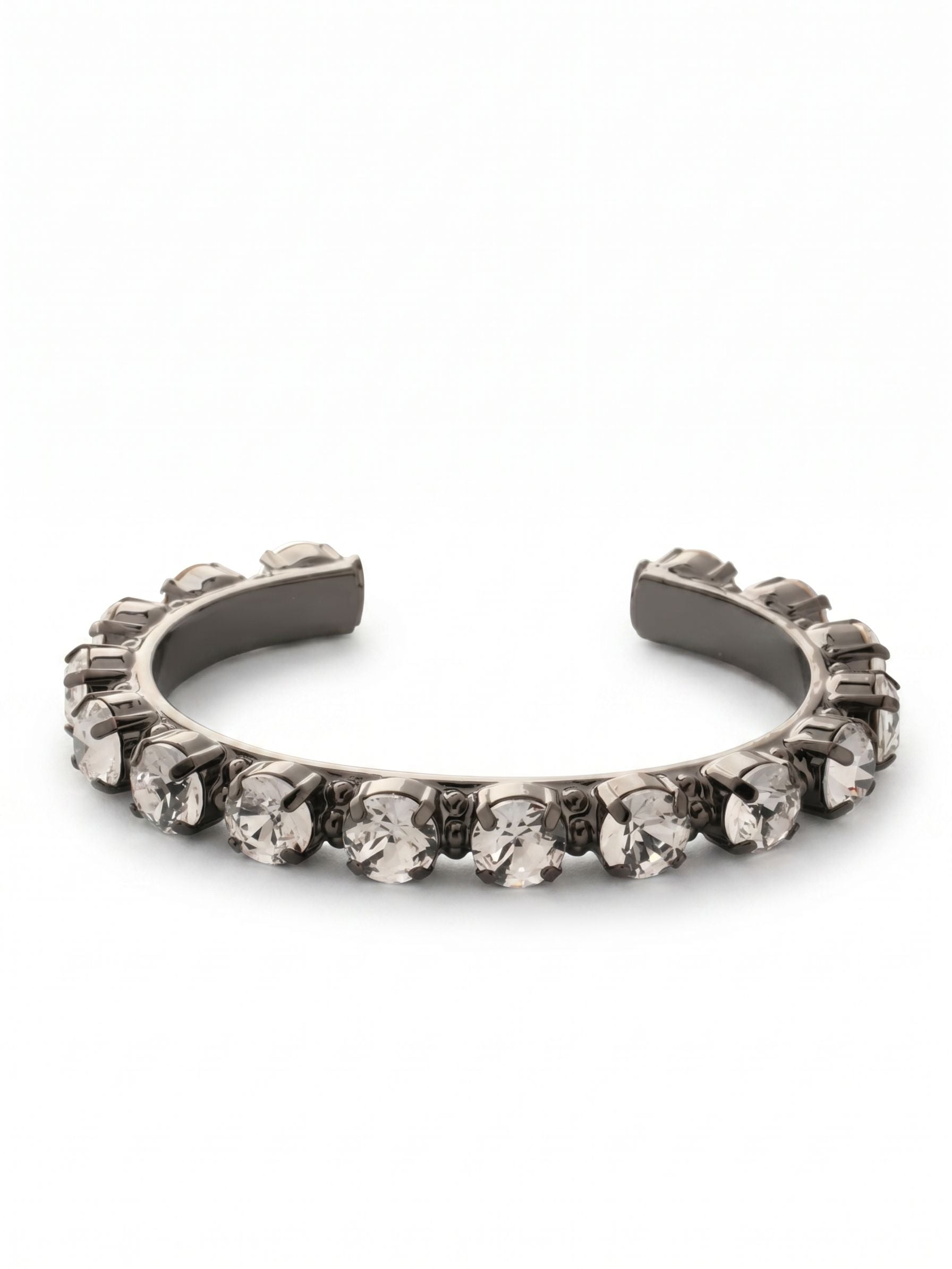 Riveting Romance Cuff Bracelet - BCL23GMCRY - <p>A continuous row of substantial round crystals catches the light against the deep gun metal finish of this structured cuff. The open design easily slips onto your wrist, offering a secure hold without the friction of clasps. Each clear stone is individually set to maximize brilliance, creating a distinct line of brightness that grounds a layered stack or stands confidently on its own. The solid framework allows you to find an ideal fit that moves naturally with you throughout your day.</p><ul>
<li>Substantial round-cut crystals set along a structured framework</li>
<li>High-contrast design pairing bright stones with dark metal</li>
<li>Adjustable open cuff slides on easily</li>
<li>Includes signature organza pouch for gifting and travel</li>
</ul>