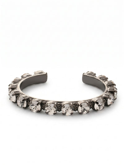 Riveting Romance Cuff Bracelet - BCL23GMCRY - <p>A continuous row of substantial round crystals catches the light against the deep gun metal finish of this structured cuff. The open design easily slips onto your wrist, offering a secure hold without the friction of clasps. Each clear stone is individually set to maximize brilliance, creating a distinct line of brightness that grounds a layered stack or stands confidently on its own. The solid framework allows you to find an ideal fit that moves naturally with you throughout your day.</p><ul>
<li>Substantial round-cut crystals set along a structured framework</li>
<li>High-contrast design pairing bright stones with dark metal</li>
<li>Adjustable open cuff slides on easily</li>
<li>Includes signature organza pouch for gifting and travel</li>
</ul>