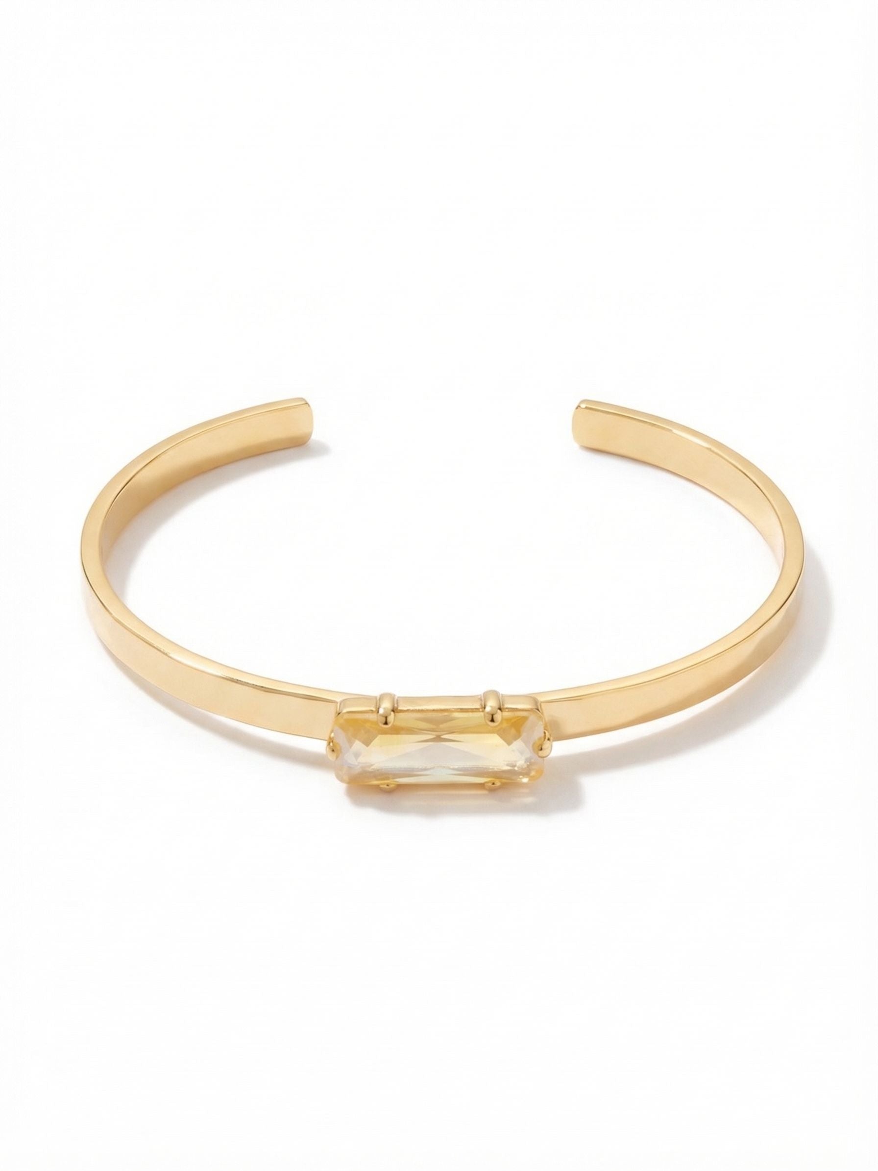 Bindi Cuff Bracelet - BCW13BGLTD - <p>A single horizontal baguette crystal anchors this slim, polished cuff. The warm light topaz catches the light naturally, drawing the eye without demanding attention. It slips gently onto the arm, offering a clean line that works beautifully on its own or tucked next to a classic watch. The open framework allows for a flexible, secure fit, making it a comfortable companion for both quiet mornings and busy afternoons.</p><ul>
<li>Single horizontal baguette-cut crystal creates a sleek focal point</li>
<li>Slim polished metal band designed for effortless layering</li>
<li>Adjustable open cuff slides on easily</li>
<li>Protective e-coat finish for lasting wear</li>
<li>Includes signature organza pouch for gifting and travel</li>
</ul>