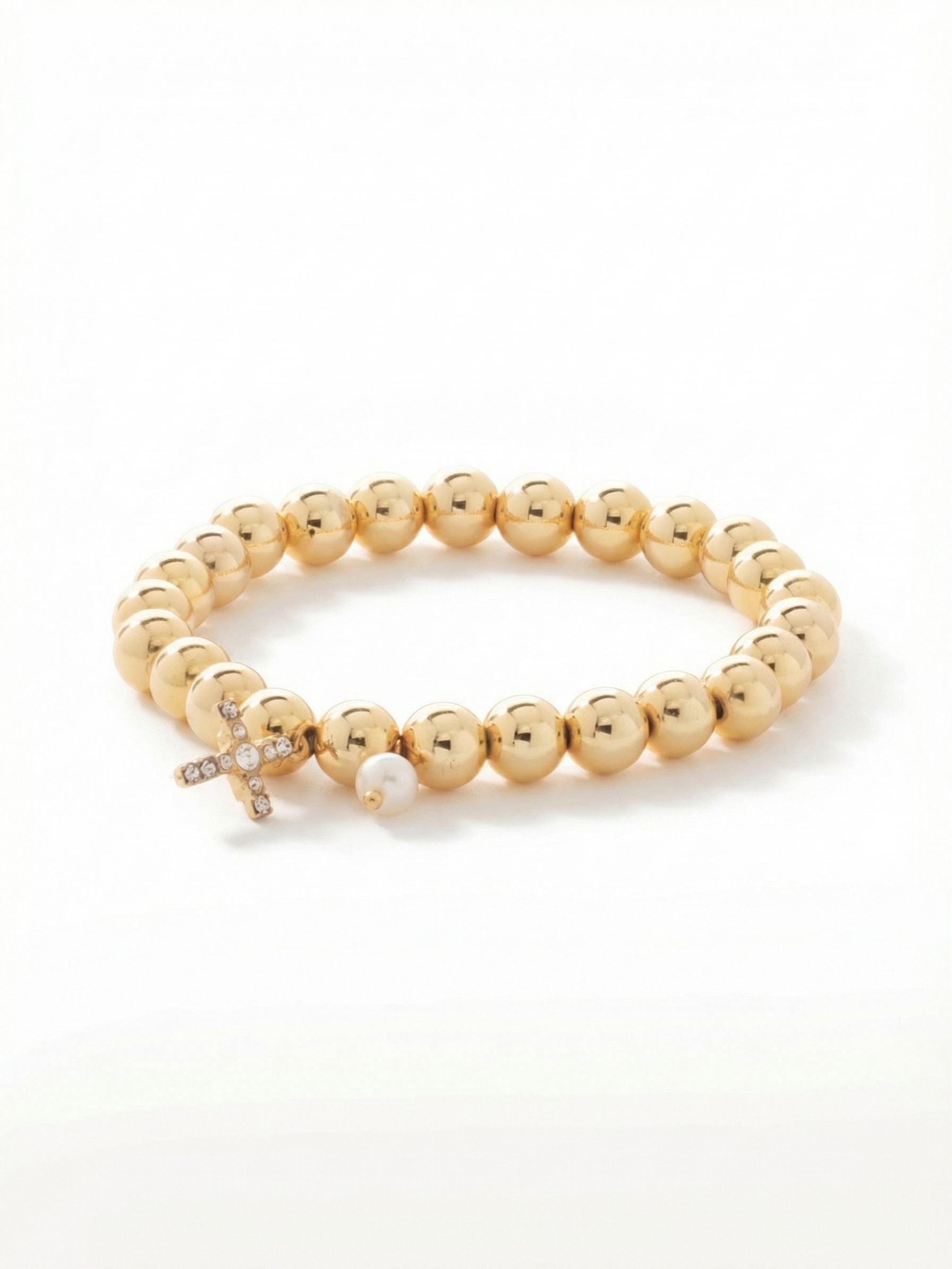 Cross & Pearl Zola Stretch Bracelet - BEX8BGCRY - <p>Large, polished gold-tone beads form the foundation of this stretch bracelet, slipping effortlessly over your hand for an immediate fit. A delicate cross charm set with round-cut clear crystals catches the light alongside a single white pearl, adding soft movement to your wrist. The spherical beads roll easily as you move, giving the piece a satisfying weight that works beautifully worn alone or anchored within a favorite daily stack.</p><ul>
<li>Smooth spherical beads offset by a delicate crystal-set cross and pearl charm</li>
<li>Subtle charm movement brings a tactile element to everyday styling</li>
<li>Stretch easy slip-on design</li>
<li>Protective e-coat finish for lasting wear</li>
<li>Includes signature organza pouch for gifting and travel</li>
</ul>