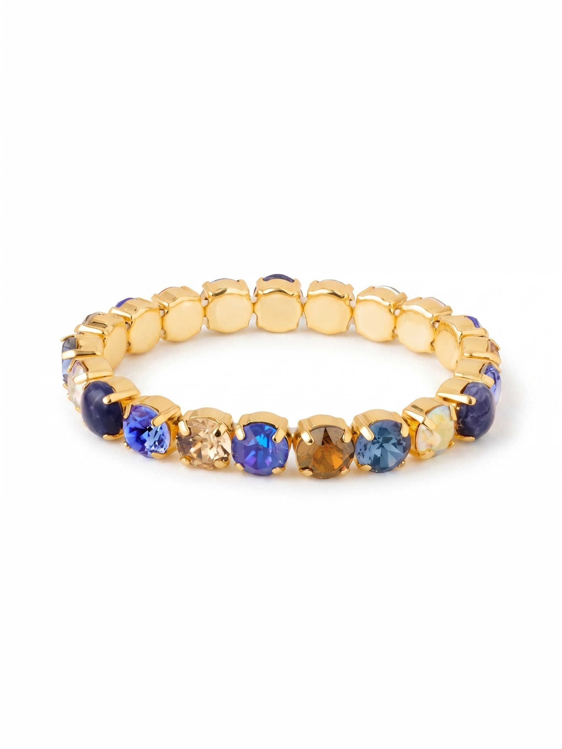 7 inch Sienna Stretch Bracelet - BFD50BGDNM - <p>Deep blue sodalite stones intersperse with faceted sapphire and smoked topaz crystals, forming a rich gradient of color that catches the light as you move. The bright gold settings warm these cool denim hues, framing each round cut with polished structure. Built on a flexible base, the design glides right over your hand, offering immediate comfort and a secure fit without the fuss of a clasp. It maintains its shape while providing the gentle give needed for active, daily wear.</p><ul>
<li>Alternating opaque sodalite and faceted crystals in a repeating round-cut pattern</li>
<li>A balanced palette of deep denim blues and warm earth tones</li>
<li>Stretch easy slip-on design</li>
<li>Protective e-coat finish for lasting wear</li>
<li>Includes signature organza pouch for gifting and travel</li>
</ul>