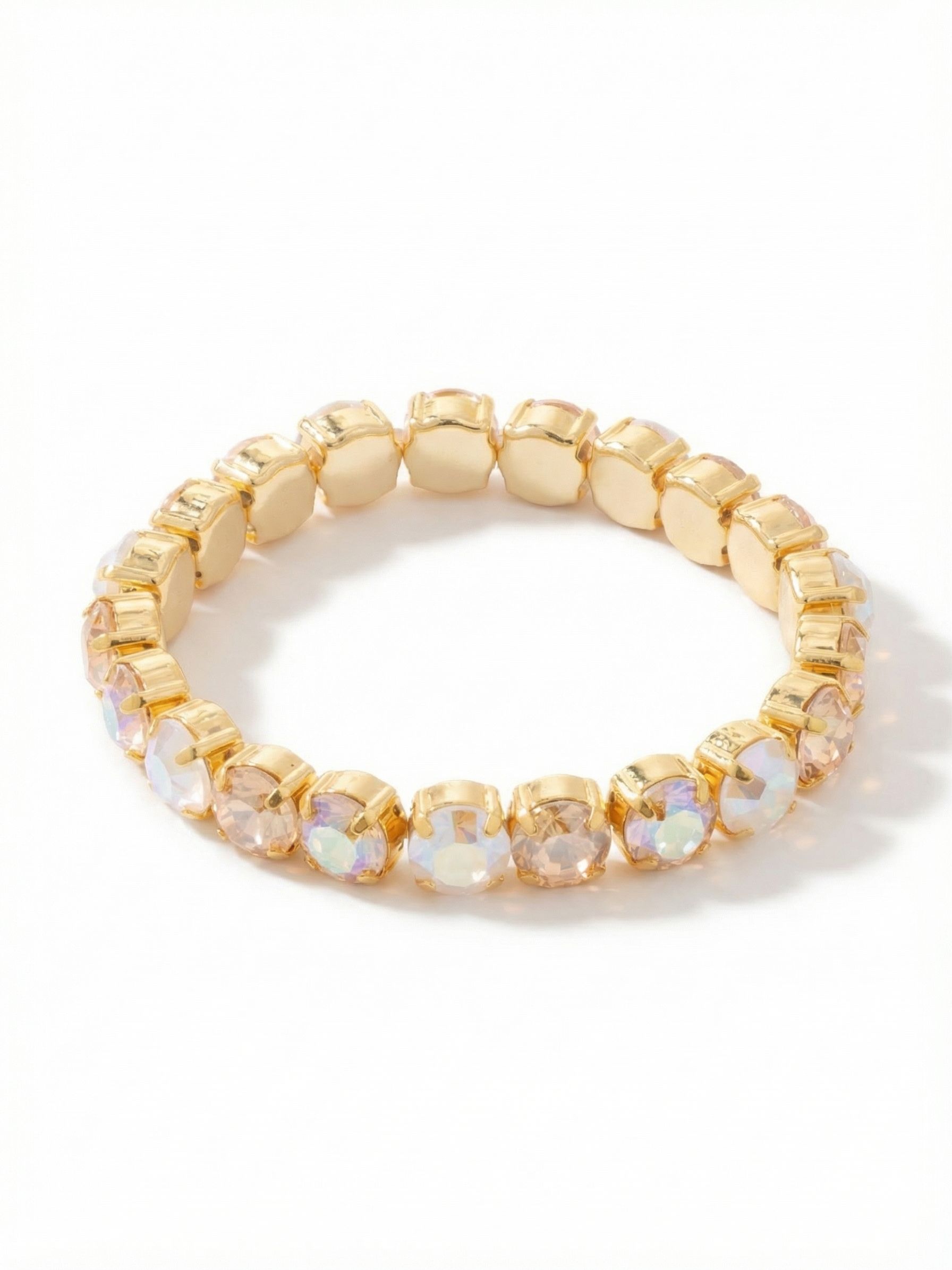 7 inch Sienna Stretch Bracelet - BFD50BGGGO - <p>A continuous band of large round crystals wraps your arm in warm champagne tones and subtle iridescent shifts. Built on a flexible interior cord, this piece slides effortlessly over your hand and adapts to your movements without the need for a clasp. The repeating sequence of golden shadow and clear stones catches the ambient light from every angle. It holds its own next to a favorite watch or serves as a glowing foundation for layered pieces.</p><ul>
<li>Alternating sequence of clear, champagne, and iridescent round crystals</li>
<li>Uniform row of large stones in connected metallic settings</li>
<li>Stretch easy slip-on design</li>
<li>Protective e-coat finish for lasting wear</li>
<li>Includes signature organza pouch for gifting and travel</li>
</ul>