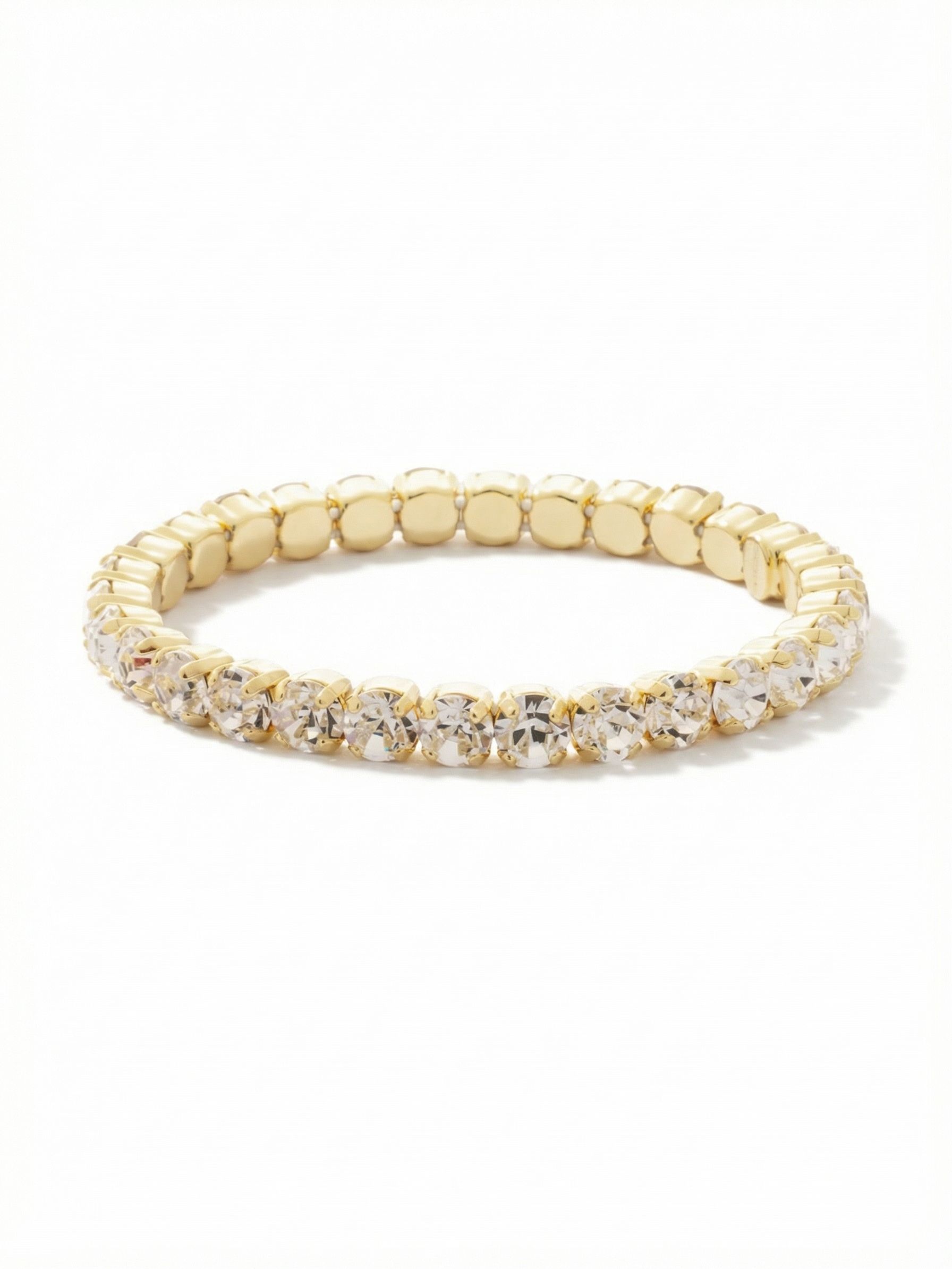 Mini Sienna Stretch Bracelet - BFD52BGCRY - <p>An unbroken circle of light that rolls effortlessly over your hand. Built with twenty-eight clear round-cut crystals, this stretch design skips the clasp entirely for instant wearability. The stones settle into a comfortable rhythm on your arm, bringing a bright, steady presence that catches the light as you move through the day. The warm gold-tone setting gives it enough visual weight to anchor a mixed metal stack or carry the conversation entirely on its own.</p><ul>
<li>Continuous circle of round-cut crystals creates an unbroken line of light</li>
<li>Substantial stone scale offers significant presence for a layered look</li>
<li>Stretch easy slip-on design</li>
<li>Protective e-coat finish for lasting wear</li>
<li>Includes signature organza pouch for gifting and travel</li>
</ul>