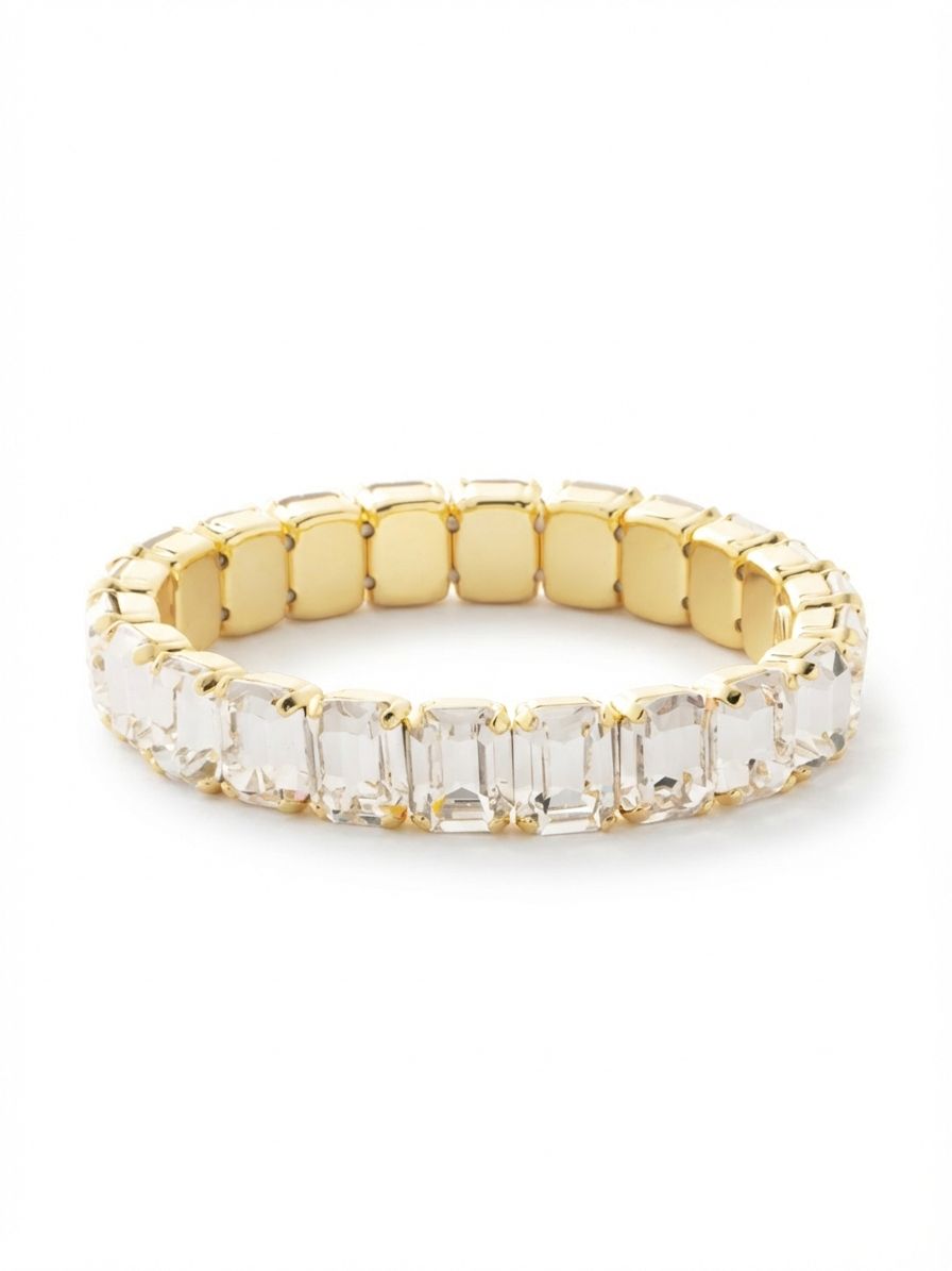 7 inch Octavia Stretch Bracelet - BFM30BGCRY - <p>A continuous line of emerald-cut clear crystals creates a clean, architectural geometry around the wrist. The substantial rectangular stones catch light with long, linear flashes that read as both classic and unexpectedly modern. Because the bright gold-tone settings are connected by an internal stretch cord, this piece rolls easily over the hand with no clasp to navigate. The articulated design conforms naturally to your movements throughout the day. It holds its own beautifully worn solo or anchors a mixed stack of softer chains.</p><ul>
<li>Unbroken line of substantial emerald cuts creates clean geometric reflection</li>
<li>Flexible articulated links conform precisely to the wrist in motion</li>
<li>Stretch easy slip-on design</li>
<li>Protective e-coat finish for lasting wear</li>
<li>Includes signature organza pouch for gifting and travel</li>
</ul>