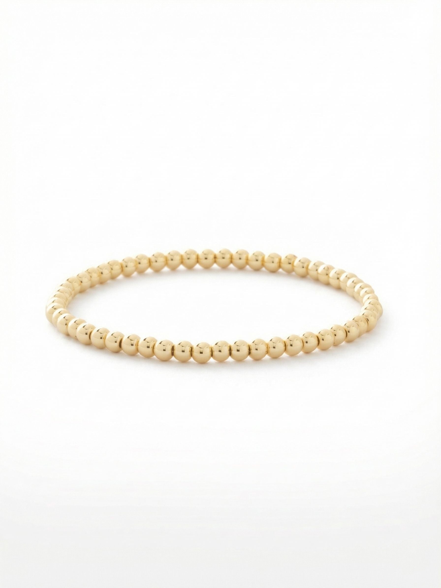 Mini Zola Stretch Bracelet - BFN20BGMTL - <p>A foundational texture for your daily rotation. This bracelet is formed from a continuous loop of highly polished metallic spheres. The stretch construction allows it to roll effortlessly over your hand, delivering immediate polish without the fuss of a clasp. At a delicate eighth of an inch wide, it provides a clean, uniform gleam in bright gold-tone metal. Wear it as a quiet standalone piece, or use it to add dimension and spacing between heavier cuffs and crystal bangles.</p><ul>
<li>Continuous strand of smooth metallic spheres for a uniform texture</li>
<li>Minimalist scale designed for effortless layering</li>
<li>Stretch easy slip-on design</li>
<li>Protective e-coat finish for lasting wear</li>
<li>Includes signature organza pouch for gifting and travel</li>
</ul>