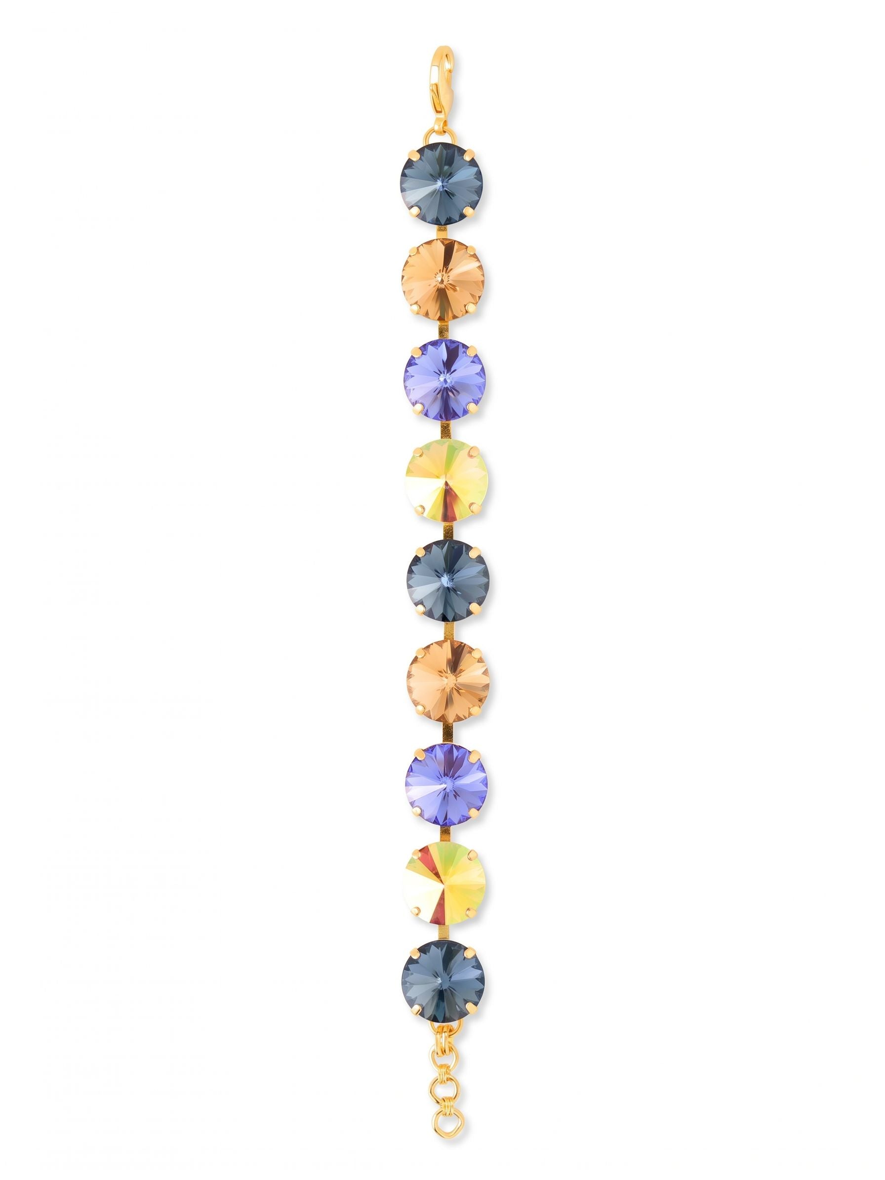 Nadine Tennis Bracelet - BFU3BGDNM - <p>A focused sequence of color and light defines this modern tennis bracelet. Nine oversized round crystals in deep denim blues and warm golden hues alternate along a flexible channel chain, responding with bright flashes to every movement of your hand. The half-inch width gives it a confident, substantial weight that feels intentional and secure. Finished with an extension chain to fine-tune the drape, it brings a grounded yet vibrant focal point to your daily uniform.</p><ul>
<li>Alternating sequence of oversized blue and gold tone crystals</li>
<li>Flexible channel construction moves fluidly with the hand</li>
<li>Lobster claw clasp</li>
<li>3/4-inch adjustable extension chain</li>
<li>Protective e-coat finish for lasting wear</li>
<li>Includes signature organza pouch for gifting and travel</li>
</ul>
