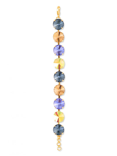 Nadine Tennis Bracelet - BFU3BGDNM - <p>A focused sequence of color and light defines this modern tennis bracelet. Nine oversized round crystals in deep denim blues and warm golden hues alternate along a flexible channel chain, responding with bright flashes to every movement of your hand. The half-inch width gives it a confident, substantial weight that feels intentional and secure. Finished with an extension chain to fine-tune the drape, it brings a grounded yet vibrant focal point to your daily uniform.</p><ul>
<li>Alternating sequence of oversized blue and gold tone crystals</li>
<li>Flexible channel construction moves fluidly with the hand</li>
<li>Lobster claw clasp</li>
<li>3/4-inch adjustable extension chain</li>
<li>Protective e-coat finish for lasting wear</li>
<li>Includes signature organza pouch for gifting and travel</li>
</ul>