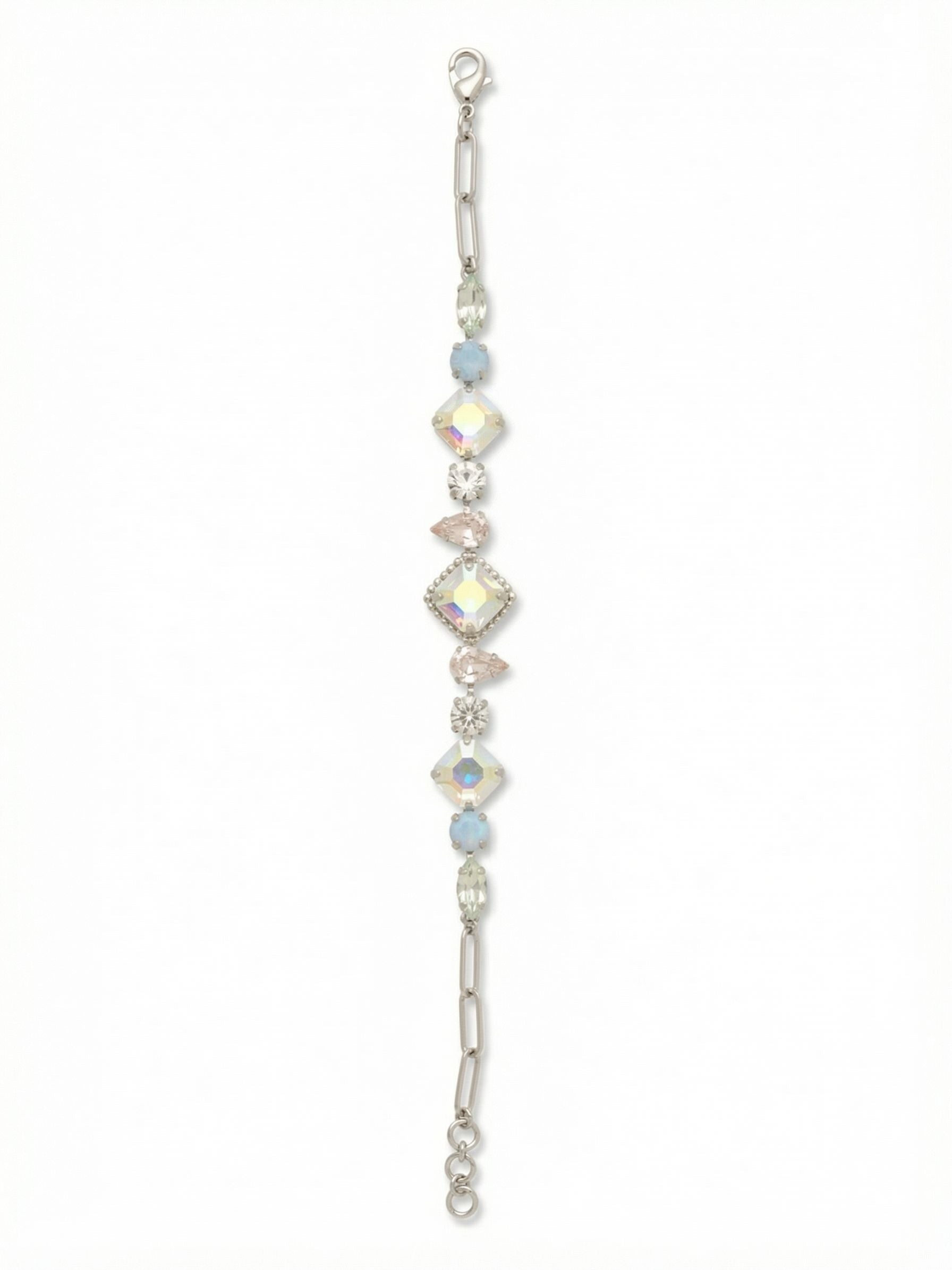Izzy Tennis Bracelet - BFY40PDRQ - <p>A departure from the uniform tennis style, this piece builds visual rhythm through alternating crystal cuts. A central square aurora borealis crystal anchors an intricate sequence of silk pear shapes, cloudy blue opals, and slender marquise stones. The shifting scale creates continuous movement as the bracelet catches the light on your arm. At each end, the setting transitions smoothly into a modern paperclip chain, while the extension links allow you to adjust the drape exactly where you want it.</p><ul>
<li>Symmetrical sequence combining square, pear, round, and marquise crystals</li>
<li>Tapered crystal settings transition into a sleek paperclip chain</li>
<li>Lobster claw clasp</li>
<li>3/4-inch adjustable extension chain</li>
<li>Protective e-coat finish for lasting wear</li>
<li>Includes signature organza pouch for gifting and travel</li>
</ul>