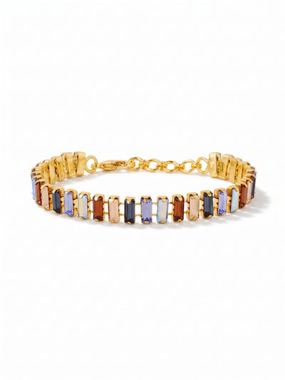Bianca Tennis Bracelet - BFY55BGDNM - <p>A structured line of vertical baguette crystals builds the foundation of this tennis bracelet. Deep sapphires and pale iridescent blues meet smoked topaz and golden shadow stones, creating a rich contrast of cool hues and warm earth tones. The articulated channel chain allows the geometric stones to flex with your natural movement, forming an unbroken rhythm around the arm. An adjustable clasp provides a tailored fit that remains comfortable from morning into evening.</p><ul>
<li>Vertical baguette crystals arranged in a repeating geometric rhythm</li>
<li>Articulated channel chain allows the structured stones to flex naturally</li>
<li>Lobster claw clasp</li>
<li>3/4-inch adjustable extension chain</li>
<li>Protective e-coat finish for lasting wear</li>
<li>Includes signature organza pouch for gifting and travel</li>
</ul>