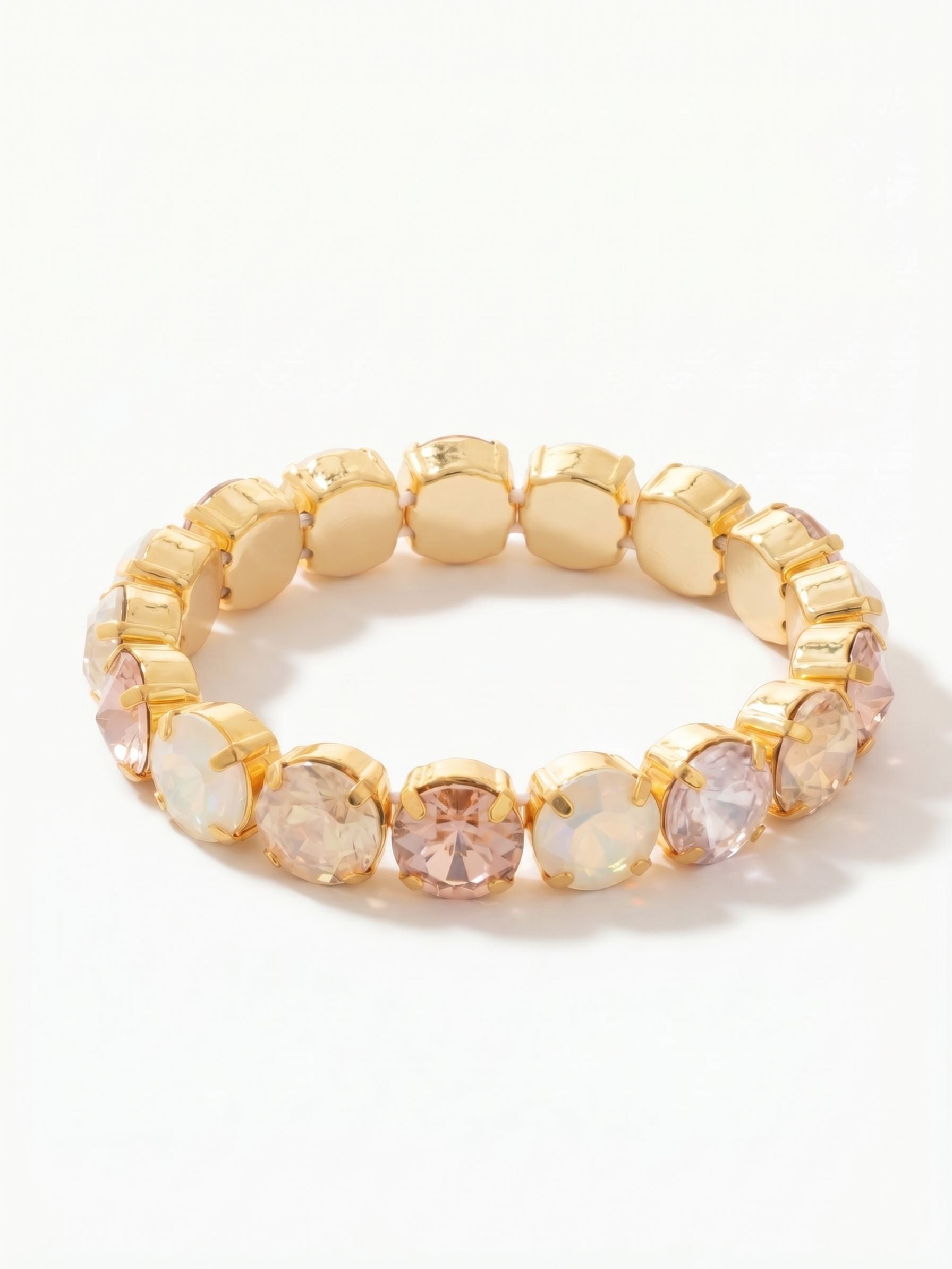 London Stretch Bracelet - BFY8BGGGO - <p>A continuous loop of large round-cut crystals slips on easily without the need to navigate a clasp. The flexible construction yields to your movement throughout the day while maintaining an unbroken line of color. Warm shades of vintage rose, pale silk, ultra white, and golden shadow catch the ambient light, grounded firmly in a bright gold-tone setting. The substantial close-set prongs create a solid band that anchors a layered stack or commands enough presence to wear alone.</p><ul>
<li>Continuous loop of large round crystals on a flexible core</li>
<li>Warm tonal palette blending blush and iridescent champagne shades</li>
<li>Stretch easy slip-on design</li>
<li>Protective e-coat finish for lasting wear</li>
<li>Includes signature organza pouch for gifting and travel</li>
</ul>
