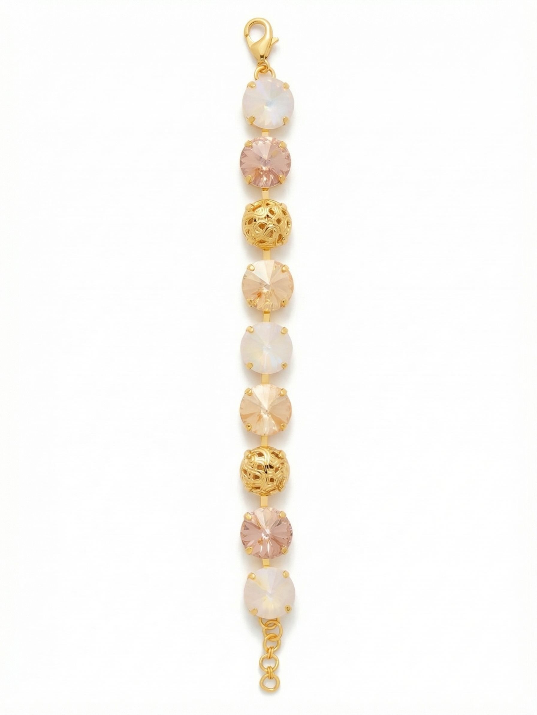 Clementine Tennis Bracelet - BFZ180BGGGO - <p>Warm blush and iridescent crystals alternate with pierced gold-tone metalwork to create a bracelet with substantial visual weight and a surprisingly fluid feel. The larger profile gives this piece clear presence on your arm, while the soft golden palette keeps the look completely versatile for daily wear. Built on an articulated channel setting, the stones catch natural light beautifully in motion. An extension chain allows you to adjust the drape exactly to your preference.</p><ul>
<li>Alternating sequence of oversized round crystals and textured filigree spheres</li>
<li>Warm tonal palette mixing blush pinks with shifting aurora borealis light</li>
<li>Lobster claw clasp</li>
<li>3/4-inch adjustable extension chain</li>
<li>Protective e-coat finish for lasting wear</li>
<li>Includes signature organza pouch for gifting and travel</li>
</ul>