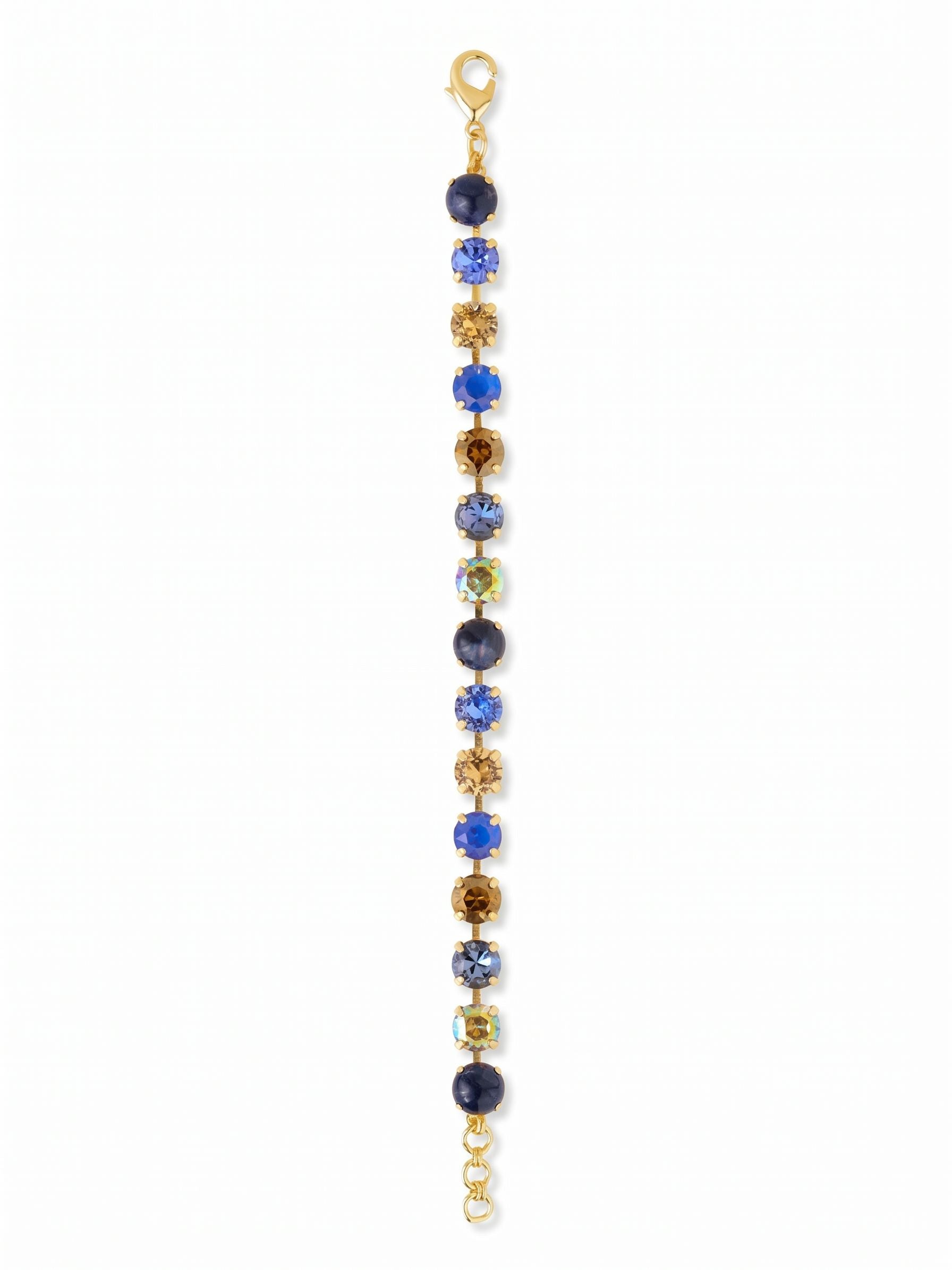 Sienna Tennis Bracelet - BGA2BGDNM - <p>Deep, opaque sodalite anchors a line of sparkling crystals in shades of sapphire, smoked topaz, and iridescent aurora borealis. The kette chain construction allows each round-cut stone to articulate individually, creating a fluid movement that tracks the natural motion of your arm. The alternating mix of earthy and denim-inspired blues brings a grounded, textural feel to the classic line silhouette. An extension chain lets you adjust the length for a tailored, secure fit from morning to evening.</p><ul>
<li>Alternating opaque sodalite and faceted crystals create textural depth</li>
<li>Fluid chain construction articulates with every movement of the wrist</li>
<li>Lobster claw clasp</li>
<li>3/4-inch adjustable extension chain</li>
<li>Protective e-coat finish for lasting wear</li>
<li>Includes signature organza pouch for gifting and travel</li>
</ul>