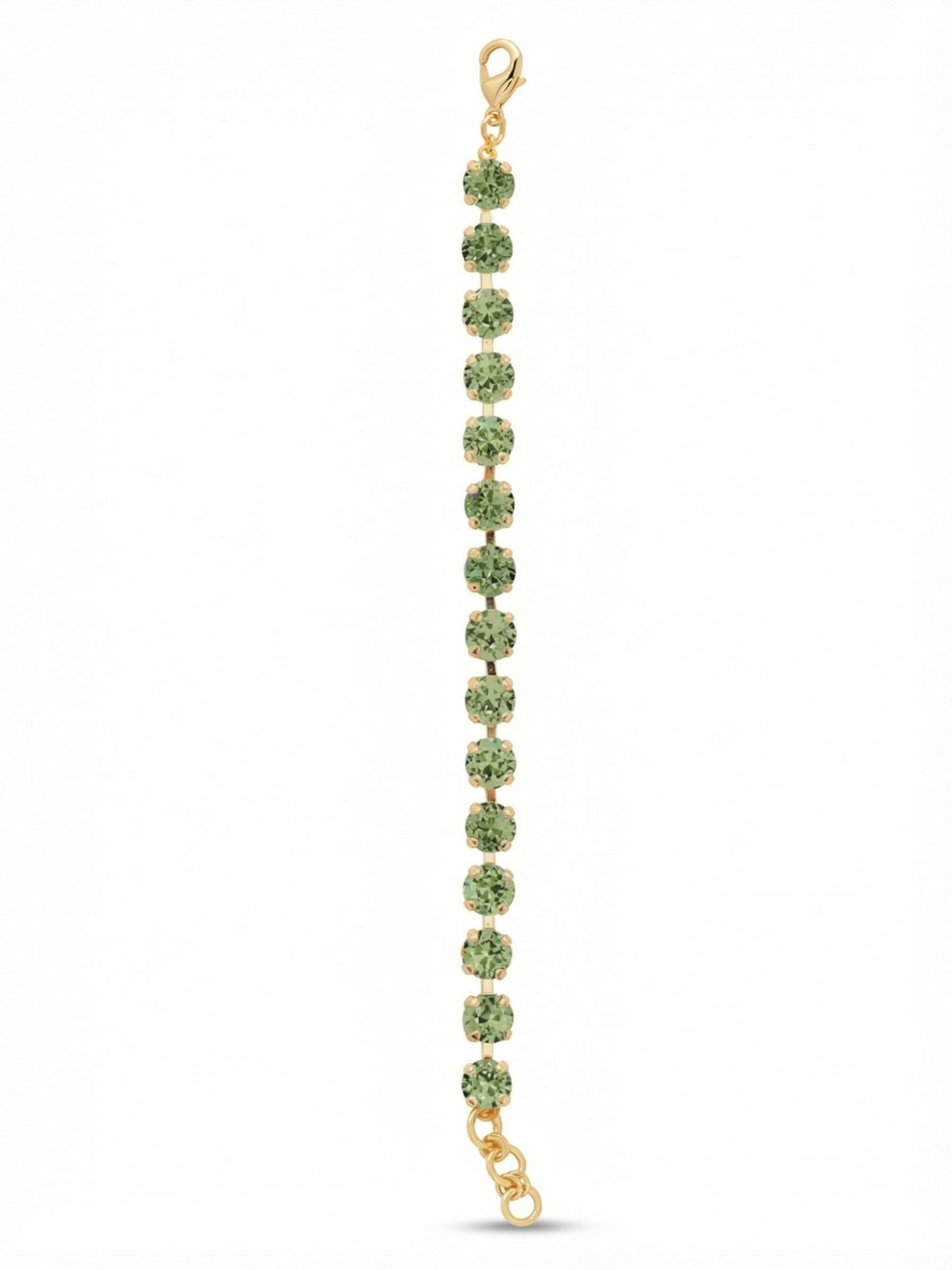 Sienna Tennis Bracelet - BGA2BGPER - <p>A continuous line of crisp peridot crystals brings immediate color and presence to your daily stack. The substantial round stones offer a satisfying weight, set closely together in a flexible channel chain that moves naturally as you go about your day. Bright gold metal warms the green facetwork, catching the light with every casual gesture. An adjustable extension allows you to find the exact right fit to keep the stones facing forward.</p><ul>
<li>Substantial round crystals bring noticeable scale and visual weight</li>
<li>Flexible channel chain construction fluidly follows your movements</li>
<li>Lobster claw clasp</li>
<li>3/4-inch adjustable extension chain</li>
<li>Protective e-coat finish for lasting wear</li>
<li>Includes signature organza pouch for gifting and travel</li>
</ul>