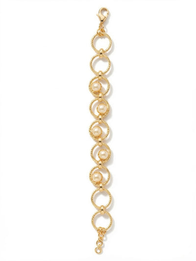 Odessa Tennis Bracelet - BGI1BGMDP - <p>Textured gold-tone rings interlock to form an open, airy chain. Five round white pearls nestle within the center links, offering a modern geometry that rethinks the classic pearl bracelet. The twisted rope texture of the metal catches the light, while the open framework keeps the piece lightweight and fluid in motion. An adjustable extension chain ensures it drapes exactly where you want it, making it an easy companion for daily wear or layered beside a heavier cuff.</p><ul>
<li>Twisted rope metalwork contrasts with the smooth organic luster of pearls</li>
<li>Open ring construction provides a lightweight and fluid drape</li>
<li>Lobster claw clasp</li>
<li>3/4-inch adjustable extension chain</li>
<li>Protective e-coat finish for lasting wear</li>
<li>Includes signature organza pouch for gifting and travel</li>
</ul>