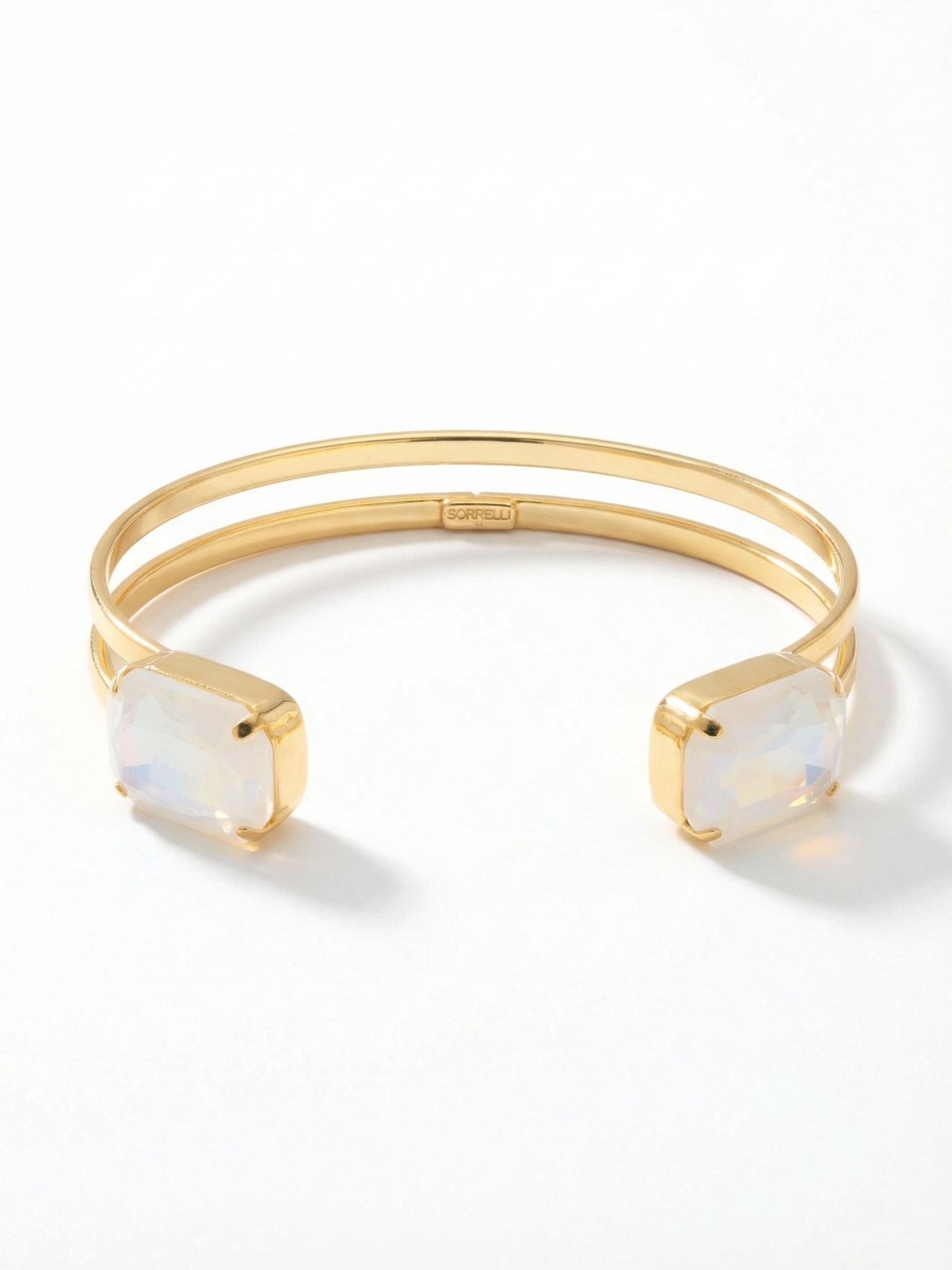 Brynn Adjustable Cuff Bracelet - BGI2BGUWAB - <p>Two prominent emerald-cut crystals anchor the ends of this open design. The split metalwork creates a structured frame of negative space, balancing the bold rectangular stones with an airy and minimalist feel. These iridescent stones catch subtle pastel shifts in the light as your hand moves. Designed to slide on effortlessly, the open cuff adapts gently to your arm for a comfortable fit that stays secure through hours of wear.</p><ul>
<li>Twin oversized emerald-cut crystals anchor the open ends</li>
<li>A split-band metal structure highlights bold negative space</li>
<li>Adjustable open cuff slides on easily</li>
<li>Protective e-coat finish for lasting wear</li>
<li>Includes signature organza pouch for gifting and travel</li>
</ul>