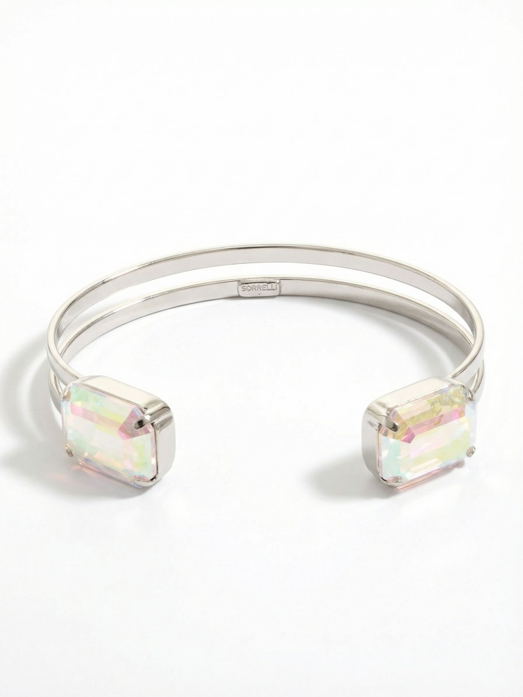 Brynn Adjustable Cuff Bracelet - BGI2PDCAB - <p>Two substantial emerald-cut crystals anchor this airy split-band design. The open metal frame offers a lightweight feel that yields gently to slide over your wrist. With every gesture, the large iridescent facets pull color from the surrounding light. It holds enough visual weight to wear alone, yet the clean lines make it an easy companion to stack alongside solid bangles or chains.</p><ul>
<li>Twin emerald-cut crystals framing an open center</li>
<li>Airy double-wire band construction</li>
<li>Adjustable open cuff slides on easily</li>
<li>Protective e-coat finish for lasting wear</li>
<li>Includes signature organza pouch for gifting and travel</li>
</ul>