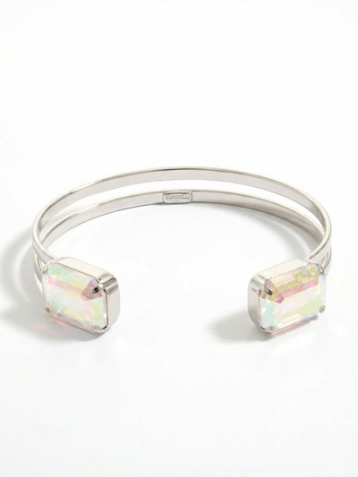 Brynn Adjustable Cuff Bracelet - BGI2PDCAB - <p>Two substantial emerald-cut crystals anchor this airy split-band design. The open metal frame offers a lightweight feel that yields gently to slide over your wrist. With every gesture, the large iridescent facets pull color from the surrounding light. It holds enough visual weight to wear alone, yet the clean lines make it an easy companion to stack alongside solid bangles or chains.</p><ul>
<li>Twin emerald-cut crystals framing an open center</li>
<li>Airy double-wire band construction</li>
<li>Adjustable open cuff slides on easily</li>
<li>Protective e-coat finish for lasting wear</li>
<li>Includes signature organza pouch for gifting and travel</li>
</ul>