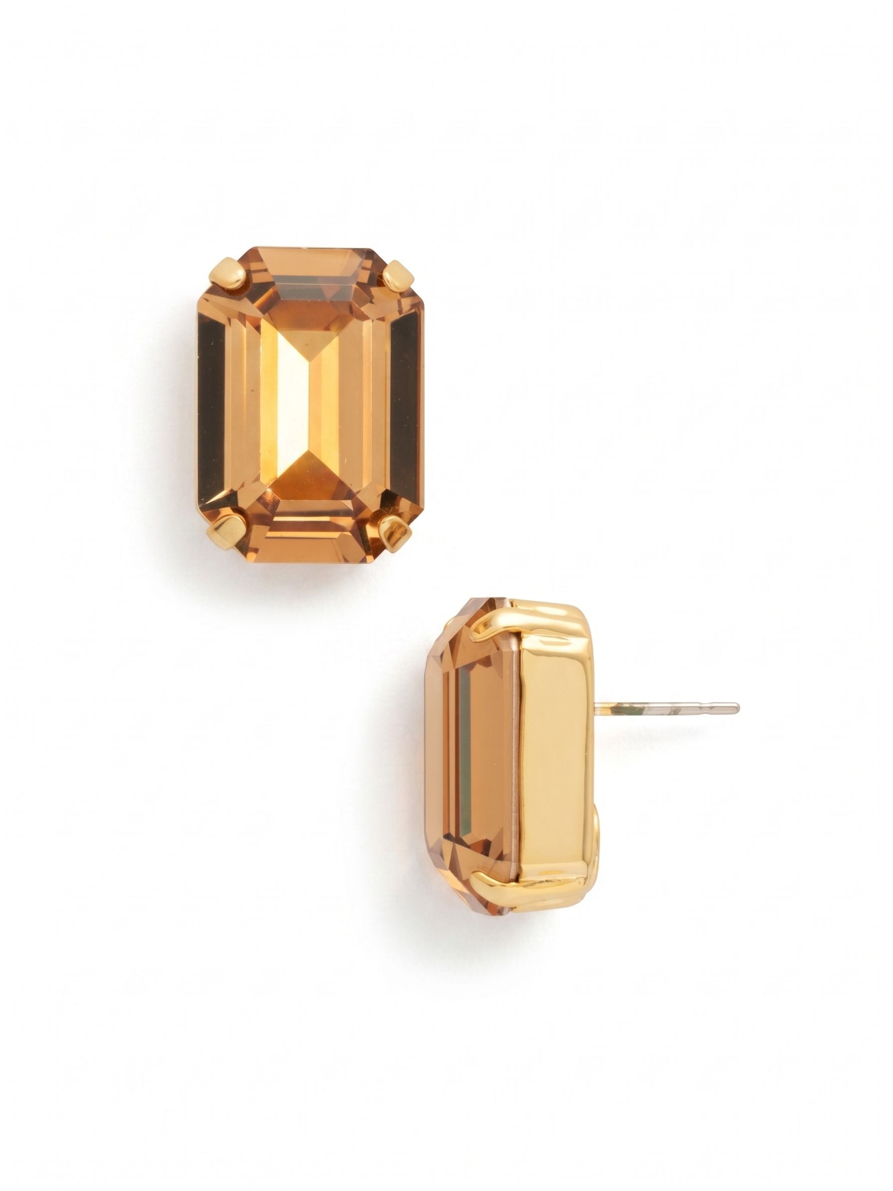 Brynn Stud Earrings - EBY44BGHNB - <p>A single, substantial emerald-cut crystal defines these post earrings. The warm honey hue catches the light with clean, architectural precision, offering distinct visual impact from conversation distance. While the three-quarter-inch scale provides a confident presence, an oversized comfort clutch ensures the setting remains perfectly upright and balanced all day. It is a grounded, everyday signature that requires no styling effort.</p><ul>
<li>Substantial emerald-cut crystal with clean architectural facets</li>
<li>Warm honey color profile with high-contrast light reflection</li>
<li>Post with oversized comfort-clutch back</li>
<li>Protective e-coat finish for lasting wear</li>
<li>Includes signature organza pouch for gifting and travel</li>
</ul>