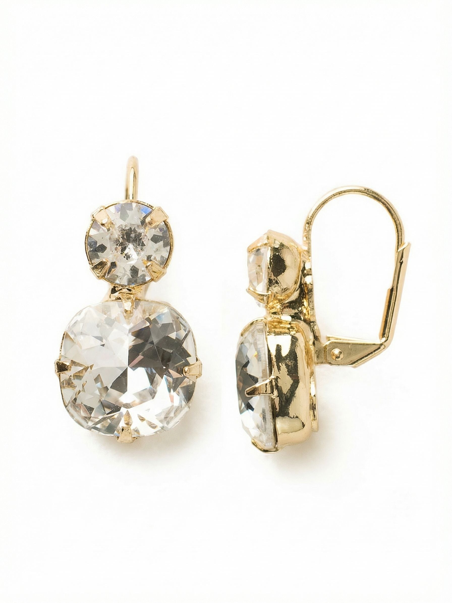 On The Edge Dangle Earrings - ECL4BGCRY - <p>Two distinct crystal cuts create a quiet focal point just below the ear. A single round crystal anchors a larger cushion cut, offering a subtle shift in geometry that catches the light as you move. The compact length keeps the swing close and comfortable from morning to evening. A hinged wire closure snaps securely into place, ensuring these clear drops feel as reliable as they look in your regular rotation.</p><ul>
<li>Stacked contrast of round and cushion cut crystals</li>
<li>Compact drop profile offering subtle movement</li>
<li>French wire for a smooth, secure fit</li>
<li>Protective e-coat finish for lasting wear</li>
<li>Includes signature organza pouch for gifting and travel</li>
</ul>