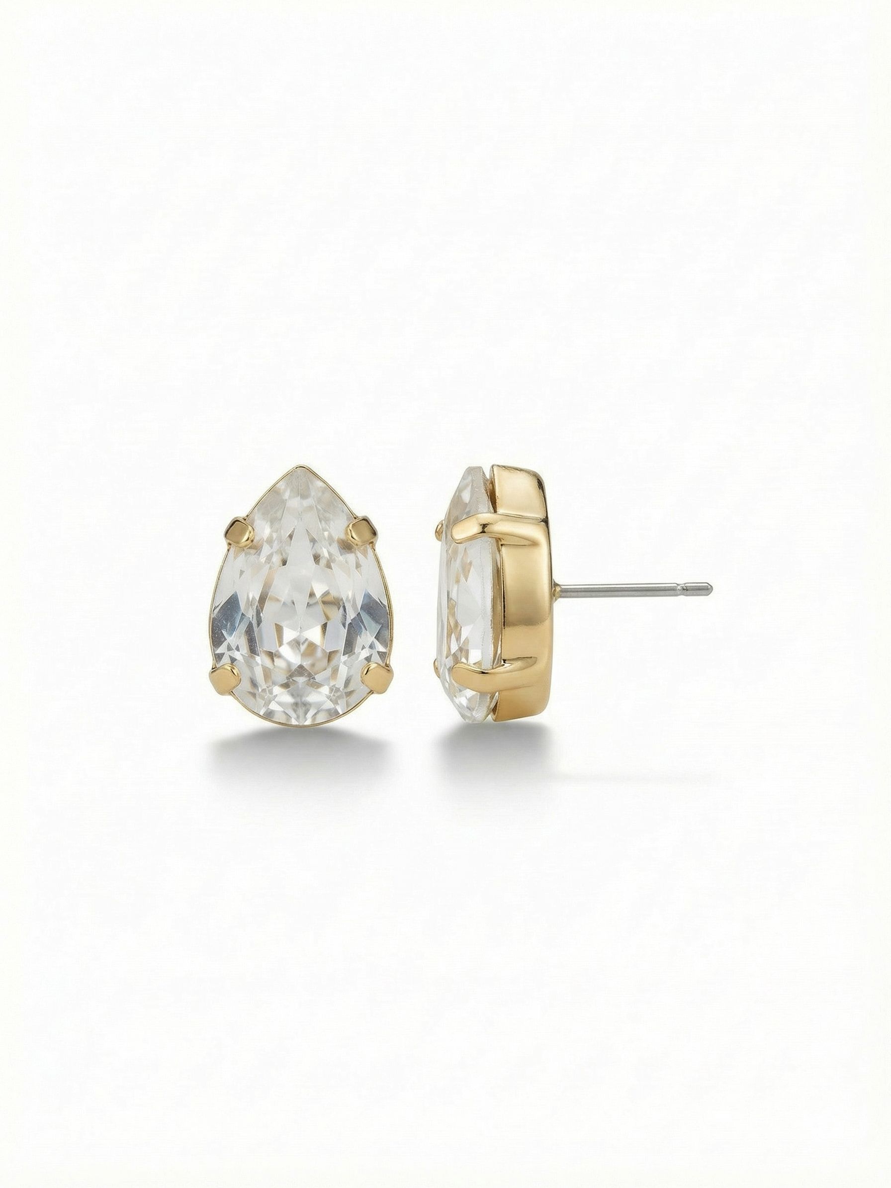 Ginnie Stud Earrings - ECR115BGCRY - <p>A single pear-cut crystal brings a clean flash of light to the face. At half an inch long, these studs offer a distinct presence that reads clearly from across a table. The bright gold-tone setting adds warmth to the clear faceted stone, offering a quiet, everyday polish. An oversized pressure-fit comfort back ensures the crystal sits securely upright all day, preventing any downward droop so the angles catch the light exactly as intended.</p><ul>
<li>Substantial half-inch scale reads clearly from conversation distance</li>
<li>Solitaire pear-cut shape offers a clean and classic profile</li>
<li>Post with oversized comfort-clutch back</li>
<li>Protective e-coat finish for lasting wear</li>
<li>Includes signature organza pouch for gifting and travel</li>
</ul>