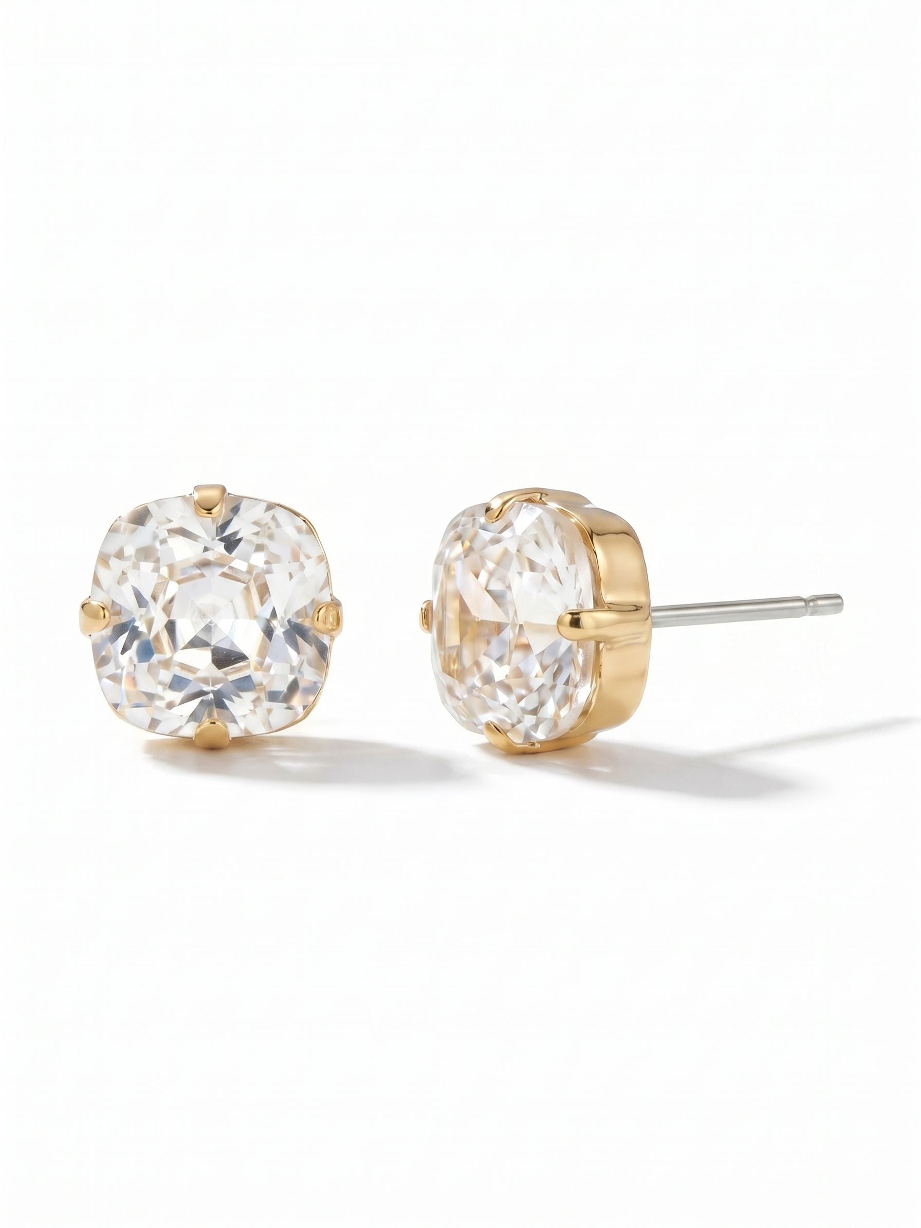 Halcyon Stud Earrings - EDH25BGCRY - <p>A solitary cushion-cut crystal forms the center of these classic studs. Measuring just under half an inch across, the faceted stone catches light naturally at conversation distance while keeping a grounded, everyday profile. The gold-tone setting brings a subtle warmth to the crisp clarity of the stone. To ensure the piece sits perfectly flush and balanced, an oversized comfort clutch secures the post, giving you effortless wear from your morning coffee through the evening.</p><ul>
<li>Cushion-cut profile offers soft geometric angles and brilliant light return</li>
<li>Substantial single-stone design reads clearly at conversation distance</li>
<li>Post with oversized comfort-clutch back</li>
<li>Protective e-coat finish for lasting wear</li>
<li>Includes signature organza pouch for gifting and travel</li>
</ul>