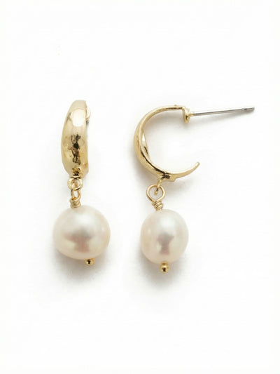 Oceane Dangle Earrings - EEF81BGMDP - <p>An organically textured bright gold-tone hoop catches the light, anchoring a single white pearl that sways gently with your movement. The contrast between the warm, subtly hammered metal and the smooth luminosity of the pearl creates a balanced, quiet presence. Built on a compact huggie base, these drop earrings sit comfortably close to the face, bringing a refined warmth to daily wear that feels completely effortless.</p><ul>
<li>Organically textured hoop contrasts with a smooth pearl drop</li>
<li>Delicate wire wrapping grounds the pearl with an artisanal touch</li>
<li>Huggie hoop with click-shut closure</li>
<li>Protective e-coat finish for lasting wear</li>
<li>Includes signature organza pouch for gifting and travel</li>
</ul>
