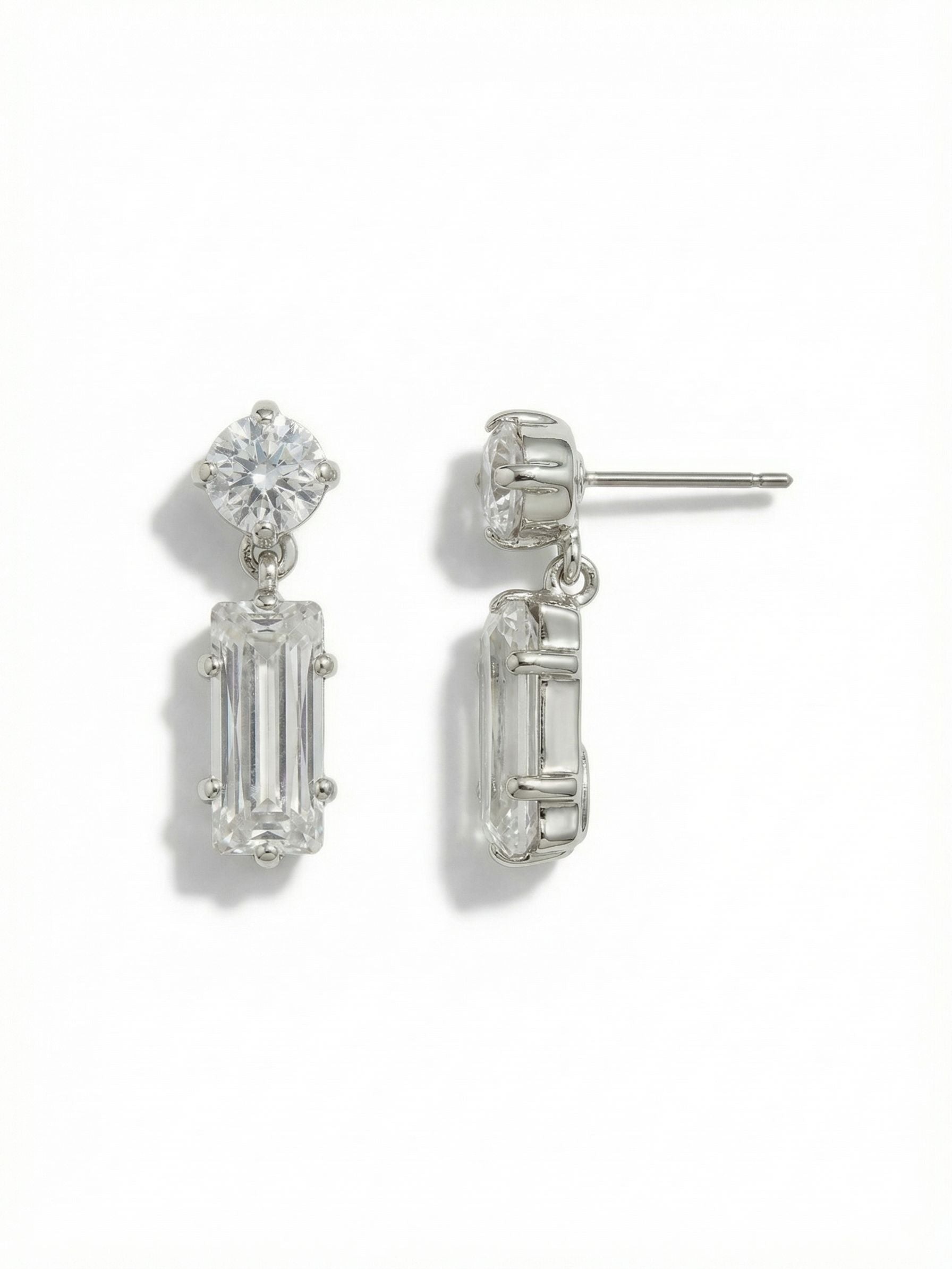 Bindi Studded Dangle Earrings - EFL13PDCRY - <p>A study in contrast. A brilliant round crystal anchors the post, suspending a long, clean baguette cut that catches the light with every turn of your head. Measuring exactly an inch, this subtle drop design delivers continuous movement while remaining light enough for daily wear. The included oversized comfort clutch ensures the geometric stones sit perfectly balanced and secure from morning until evening.</p><ul>
<li>Contrast of brilliant round and stepped baguette crystal cuts</li>
<li>Subtle drop articulation creates gentle continuous movement</li>
<li>Post with oversized comfort-clutch back</li>
<li>Protective e-coat finish for lasting wear</li>
<li>Includes signature organza pouch for gifting and travel</li>
</ul>
