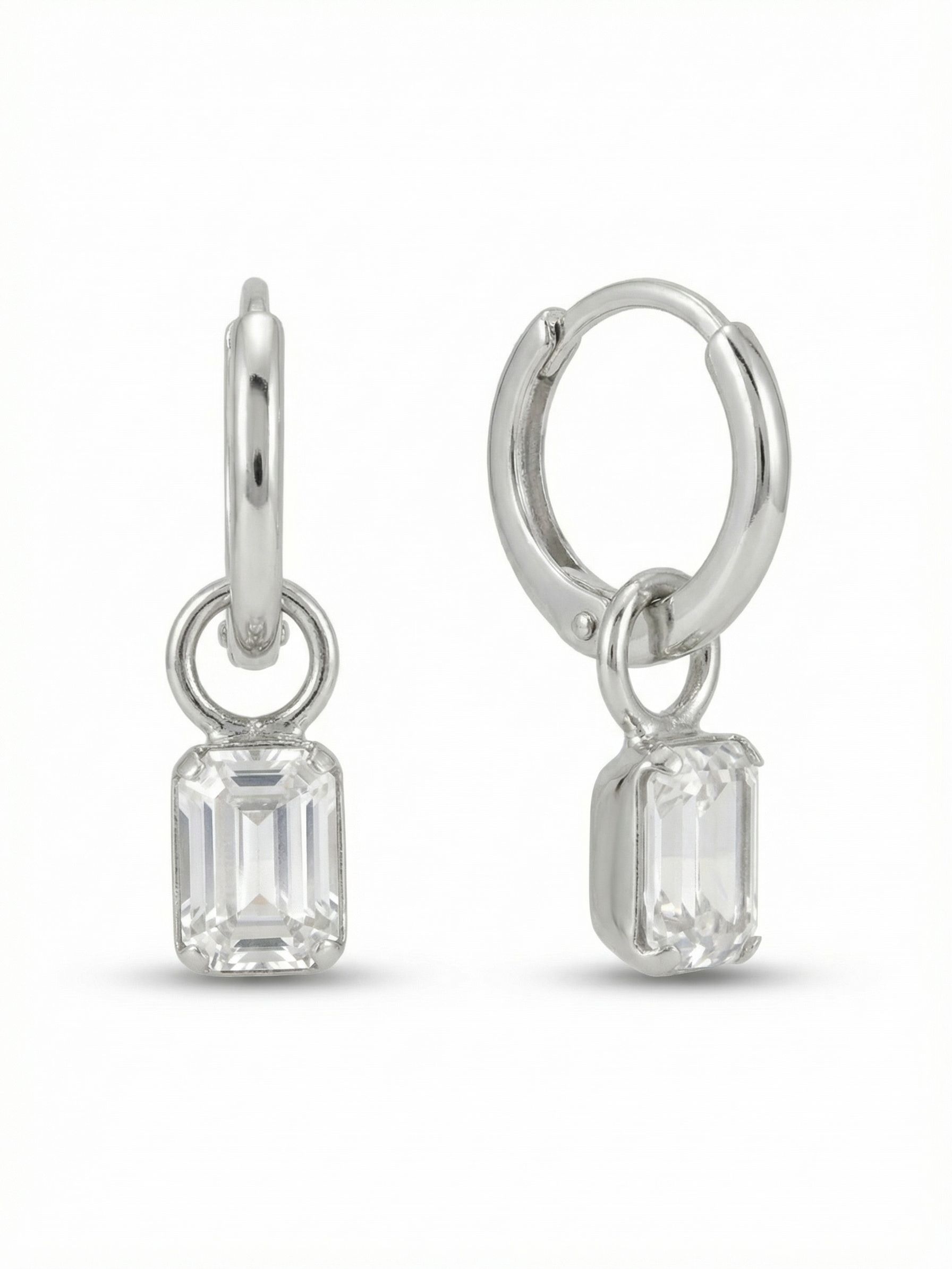 Mini Emerald Huggie Hoop Earrings - EFM13PDCRY - <p>A sleek metallic hoop sits close to the ear, anchoring a single, clean-lined emerald cut crystal. The clear stone drops freely from a polished circular jump ring, catching the light with every subtle turn of the head. The huggie design provides a secure, comfortable fit that feels almost weightless throughout the day. These earrings offer a quiet touch of modern geometry, distinct enough to stand alone but scaled perfectly to become a daily staple.</p><ul>
<li>Clean architectural lines of the emerald-cut drop</li>
<li>Free-moving circular ring design catches light in continuous motion</li>
<li>Huggie hoop with click-shut closure</li>
<li>Protective e-coat finish for lasting wear</li>
<li>Includes signature organza pouch for gifting and travel</li>
</ul>