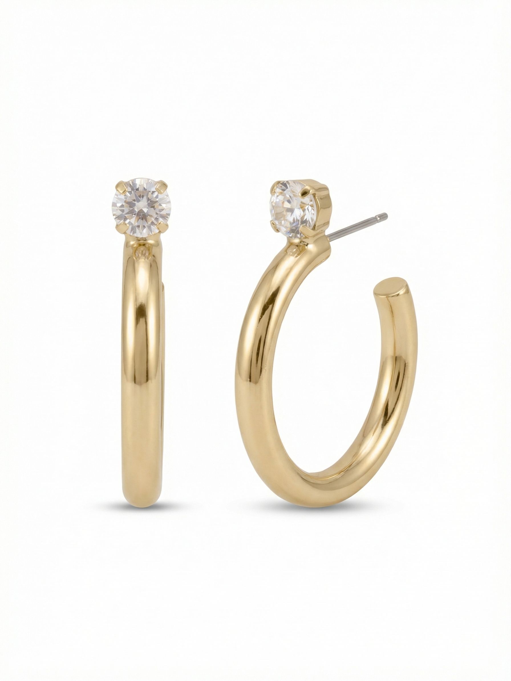 Keeley Studded Hoop Earrings - EFP26BGCRY - <p>A modern interpretation of a classic silhouette. The polished metal forms a smooth, continuous curve that anchors precisely at a single round-cut crystal. Positioned directly at the post, this stone catches the light at conversation level before the bold arc sweeps back. Measuring just under two inches, these hoops offer significant visual weight while remaining comfortable for daily wear. The included oversized comfort clutch keeps the earring secure and perfectly balanced from morning until evening.</p><ul>
<li>Single round-cut crystal positioned prominently at the top of the hoop</li>
<li>Thick tubular metal profile creates a bold and reflective presence</li>
<li>Hoop earring</li>
<li>Protective e-coat finish for lasting wear</li>
<li>Includes signature organza pouch for gifting and travel</li>
</ul>