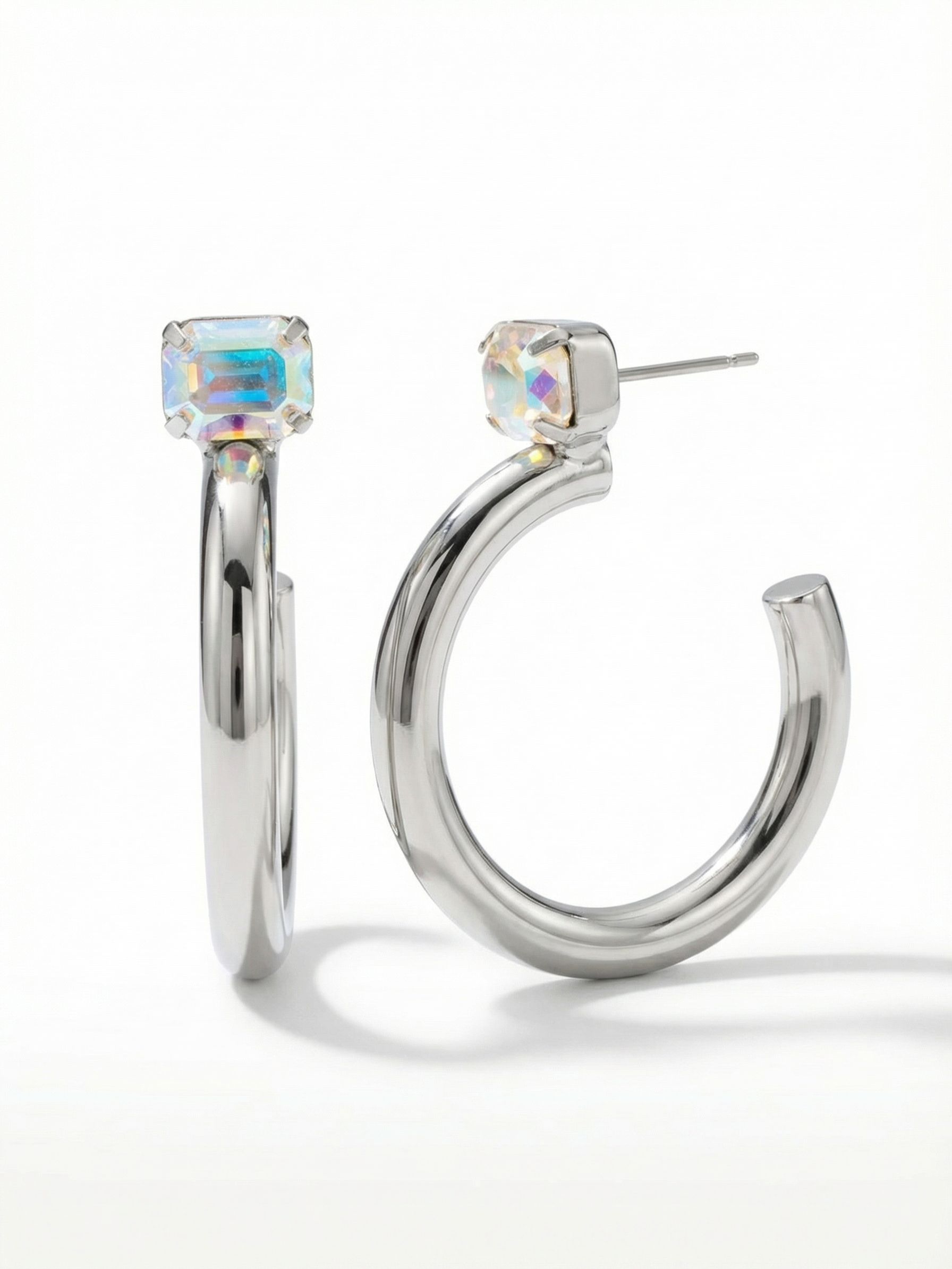 Keeley Emerald Cut Hoop Earrings - EFU6PDCAB - <p>A smooth sweep of polished metal anchors the structured geometry of an emerald-cut crystal. The single faceted stone catches iridescent light right at the ear, contrasting with the clean curve of the thick open hoop below it. Measuring nearly two inches long, these earrings carry a confident presence without pulling. An oversized pressure-fit clutch keeps the substantial shape balanced and perfectly upright, making this modern silhouette effortless to wear from morning until evening.</p><ul>
<li>Thick polished open hoop design provides a substantial modern profile</li>
<li>Solitaire emerald-cut crystal creates a geometric contrast against the smooth metal curve</li>
<li>Hoop earring</li>
<li>Protective e-coat finish for lasting wear</li>
<li>Includes signature organza pouch for gifting and travel</li>
</ul>