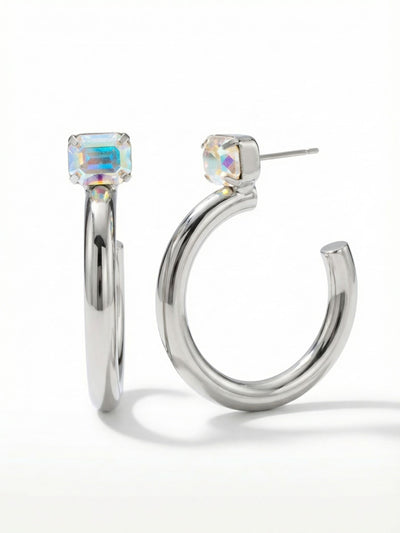 Keeley Emerald Cut Hoop Earrings - EFU6PDCAB - <p>A smooth sweep of polished metal anchors the structured geometry of an emerald-cut crystal. The single faceted stone catches iridescent light right at the ear, contrasting with the clean curve of the thick open hoop below it. Measuring nearly two inches long, these earrings carry a confident presence without pulling. An oversized pressure-fit clutch keeps the substantial shape balanced and perfectly upright, making this modern silhouette effortless to wear from morning until evening.</p><ul>
<li>Thick polished open hoop design provides a substantial modern profile</li>
<li>Solitaire emerald-cut crystal creates a geometric contrast against the smooth metal curve</li>
<li>Hoop earring</li>
<li>Protective e-coat finish for lasting wear</li>
<li>Includes signature organza pouch for gifting and travel</li>
</ul>