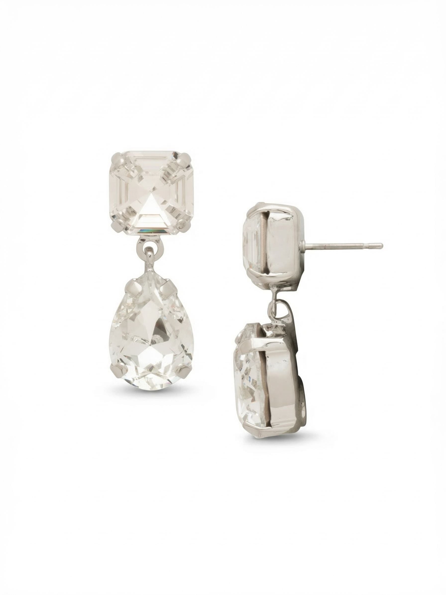 Clara Dangle Earrings - EFY4PDCRY - <p>A study in shape and light, these drop earrings pair crisp, square-cut crystal posts with softly faceted pear-shaped drops. The minimal articulated link allows the lower crystal to swing gently with your movement, catching reflections throughout the day. At three-quarters of an inch long, they deliver focused brightness without feeling heavy. An oversized comfort clutch back anchors the post securely, ensuring the geometric silhouette stays perfectly positioned from morning meetings to evening dinners.</p><ul>
<li>Crisp square top crystals contrast sharply with softly curved pear drops</li>
<li>A single articulated link allows the lower crystal to catch continuous light in motion</li>
<li>Post with oversized comfort-clutch back</li>
<li>Protective e-coat finish for lasting wear</li>
<li>Includes signature organza pouch for gifting and travel</li>
</ul>