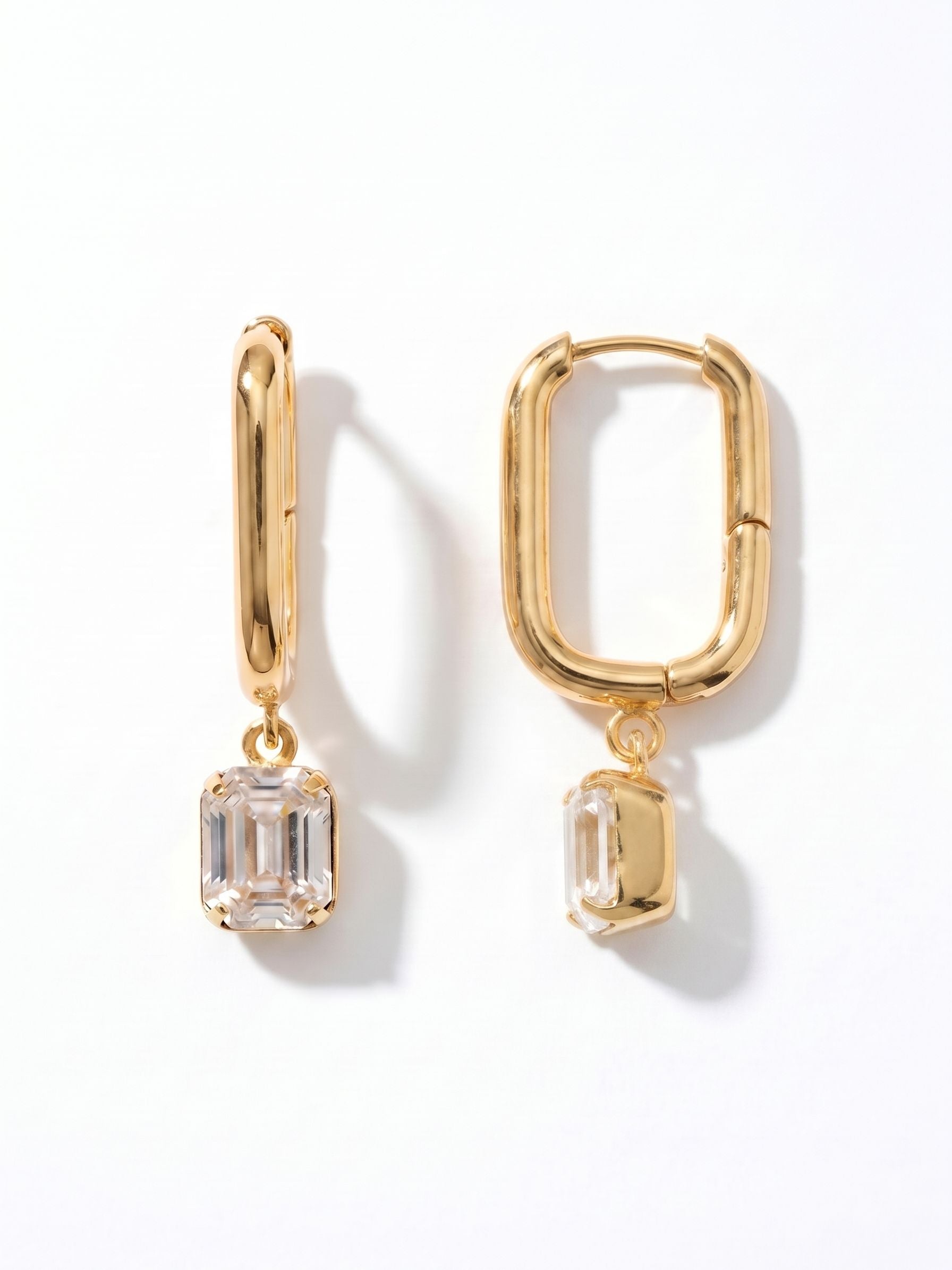 Octavia Rectangle Hoop Earrings - EFY7BGCRY - <p>Clean, rectangular geometry gives these hoops an architectural sensibility. Suspended freely from the base of the structured metal, a single emerald-cut clear crystal catches the light with every subtle movement of the head. The contrast between the rigid, modern frame and the fluid swing of the drop makes these earrings highly versatile. They secure effortlessly and feel balanced for daily wear, bridging the gap between polished daytime structure and evening elegance.</p><ul>
<li>Clean rectangular geometry paired with an emerald-cut crystal profile</li>
<li>Articulated crystal drop creates subtle movement and light reflection</li>
<li>Hinged hoop with click-shut closure</li>
<li>Protective e-coat finish for lasting wear</li>
<li>Includes signature organza pouch for gifting and travel</li>
</ul>