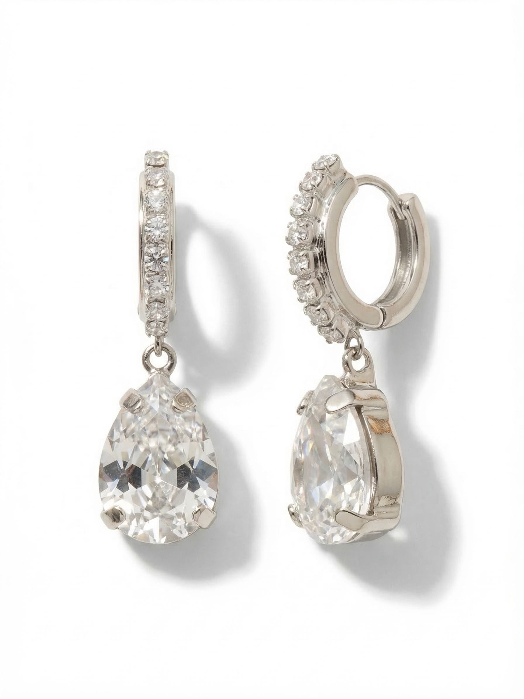 Perfect Pear Embellished Huggie Hoop Earrings - EGJ9PDCRY - <p>A delicate line of small crystals wraps closely around the ear in a secure huggie design, anchoring a single, significant pear-cut stone. The large clear crystal drop swings freely with your natural movement, catching ambient light from every angle. It balances a refined profile with enough substance to register from across the room. The cool tone of the palladium gives the piece a clean finish that integrates seamlessly into your weekly rotation.</p><ul>
<li>A delicate rhinestone-lined hoop anchors a substantial pear-cut crystal</li>
<li>The articulated drop design allows the bottom stone to swing freely</li>
<li>Huggie Hoop earring</li>
<li>Protective e-coat finish for lasting wear</li>
<li>Includes signature organza pouch for gifting and travel</li>
</ul>