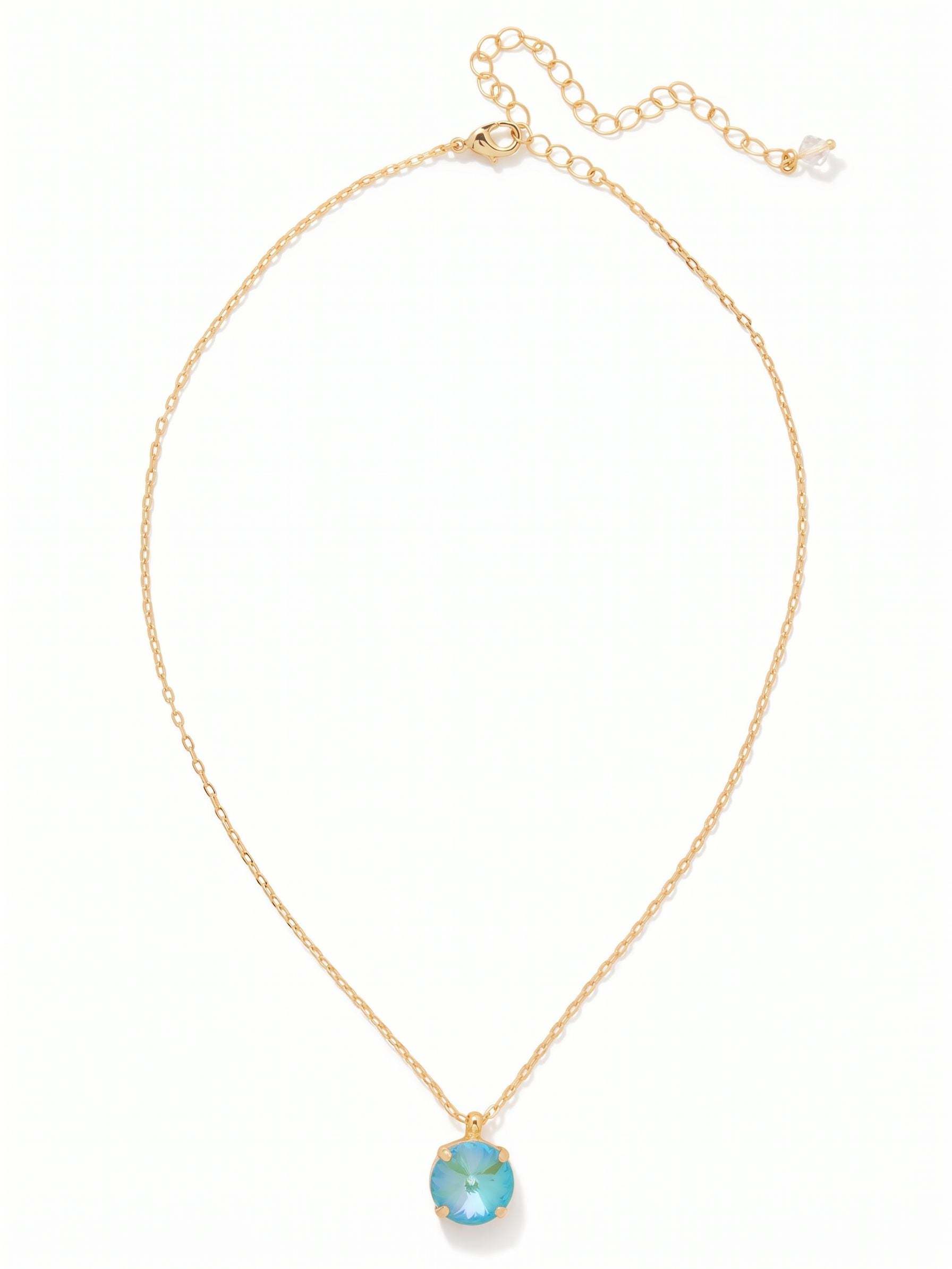Nadine Pendant Necklace - NDB83BGSBD - <p>A single, vivid blue round crystal anchors this delicate cable chain, resting naturally near the collarbone. The open, pronged setting allows light to hit the stone from all angles, bringing a clear wash of color to the neckline. Strung on a fine chain that feels almost weightless, this piece is meant to be lived in from morning until evening. A built-in extension chain gives you the flexibility to adjust the drop exactly where you want it.</p><ul>
<li>Single round-cut crystal in a minimal prong setting</li>
<li>Suspended on a fine cable chain for a weightless drape</li>
<li>Lobster claw clasp</li>
<li>4-inch adjustable extension chain</li>
<li>Protective e-coat finish for lasting wear</li>
<li>Includes signature organza pouch for gifting and travel</li>
</ul>