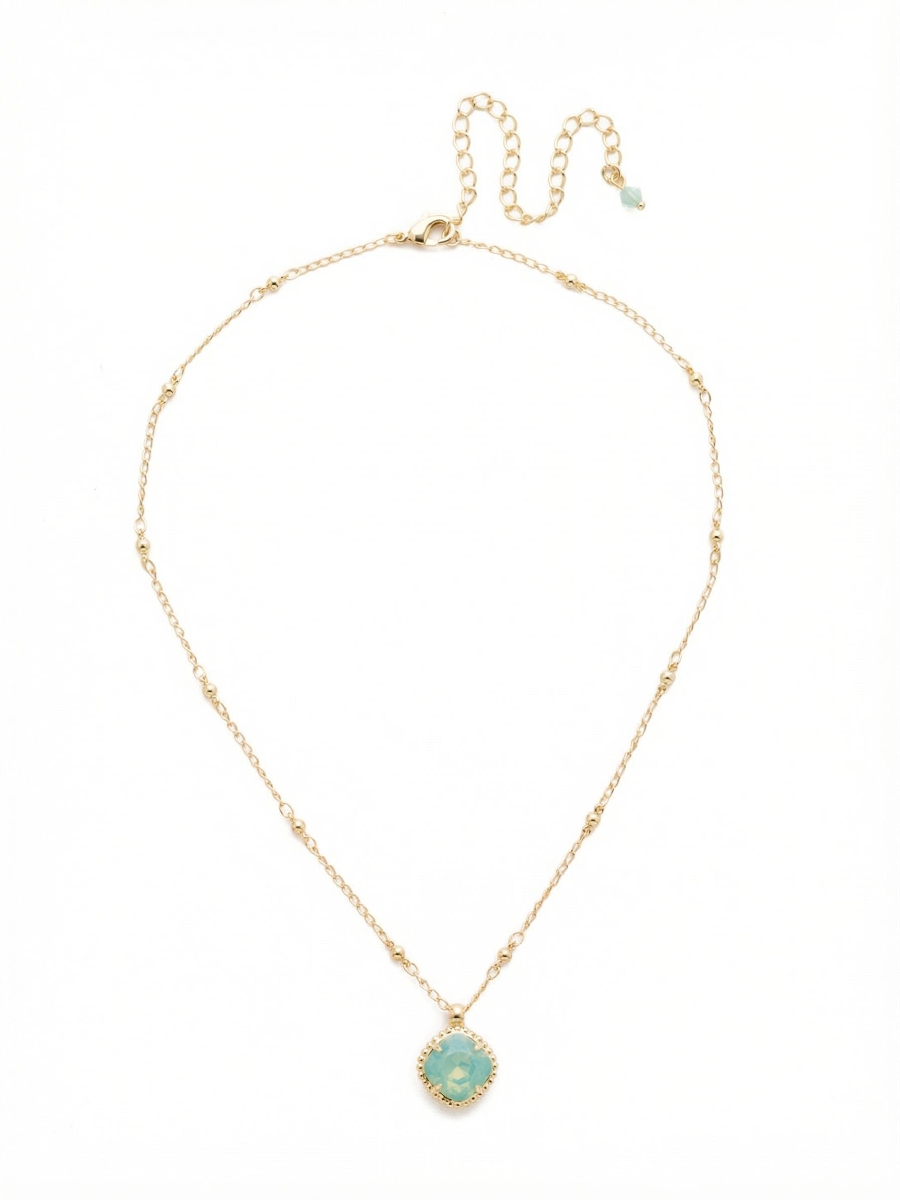 Cushion-Cut Pendant Necklace - NDS50BGPAC - <p>A single cushion-cut crystal acts as a quiet focal point at the collarbone. The pale, milky green of the Pacific Opal catches the light subtly, framed by a textured setting that adds a hint of character to the profile. It is suspended from a delicate cable chain punctuated by tiny, evenly spaced beads, giving the strand a gentle rhythm. With an adjustable extension, you can easily shift the placement to anchor a layered neckline or let it stand alone.</p><ul>
<li>Delicate cable chain punctuated by evenly spaced bead stations</li>
<li>Single cushion-cut crystal suspended in a subtly textured frame</li>
<li>Lobster claw clasp</li>
<li>4-inch adjustable extension chain</li>
<li>Protective e-coat finish for lasting wear</li>
<li>Includes signature organza pouch for gifting and travel</li>
</ul>