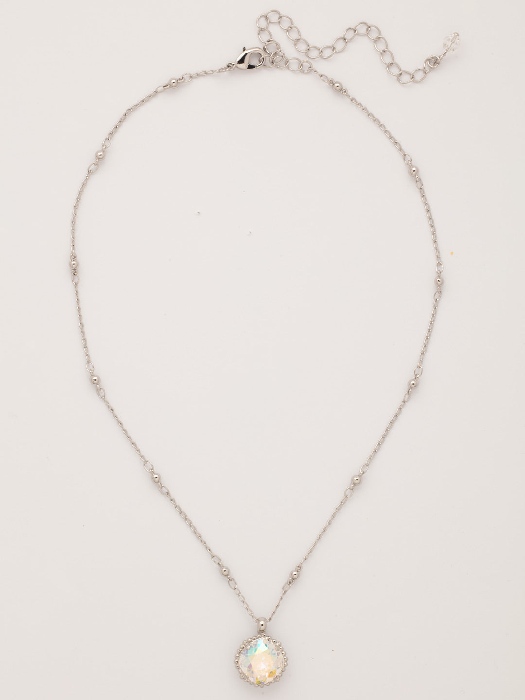 Cushion-Cut Pendant Necklace - NDS50RHCAB - <p>Elevate your jewelry collection with this artisanally handcrafted pendant necklace. The solitaire 12mm cushion cut crystal is surrounded by a beautifully scalloped edge, creating a unique and eye-catching design. The little ball details along the chain add a touch of character. This adjustable necklace features a 16 inch chain with a 4 inch extension, complete with a delicate charm, for a versatile fit. Whether you're looking for a special gift or a treat for yourself, this handcrafted necklace is a stylish and timeless choice.</p>