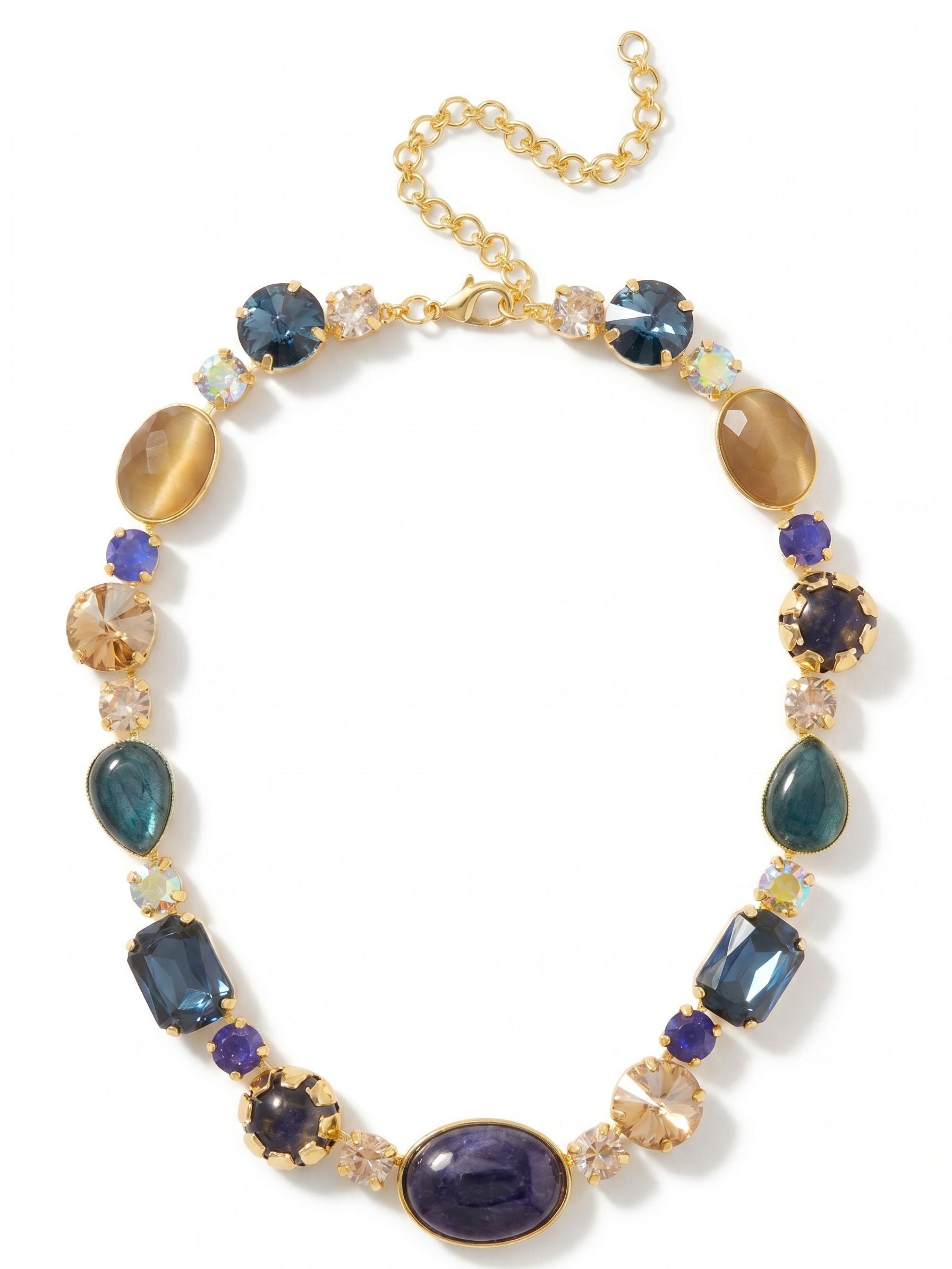 Tatiana Tennis Necklace - NEP58BGDNM - <p>A substantial take on the classic tennis line. The Tatiana anchors at the collarbone with a generous oval of opaque sodalite, giving way to a varied rhythm of emerald-cut crystals, pear-shaped labradorite, and smooth toffee cat's eye. This piece balances deep, moody blues with the unexpected warmth of golden shadow crystals. The flexible kette chain allows the heavier stone weights to drape naturally across the neckline. An included extension chain lets you fine-tune the drop to frame an open collar or sit comfortably over a high knit.</p><ul>
<li>Alternating opaque sodalite and translucent crystals that create deep visual contrast</li>
<li>Mixed stone scale and varied shapes for a substantial collarbone presence</li>
<li>Lobster claw clasp</li>
<li>4-inch adjustable extension chain</li>
<li>Protective e-coat finish for lasting wear</li>
<li>Includes signature organza pouch for gifting and travel</li>
</ul>
